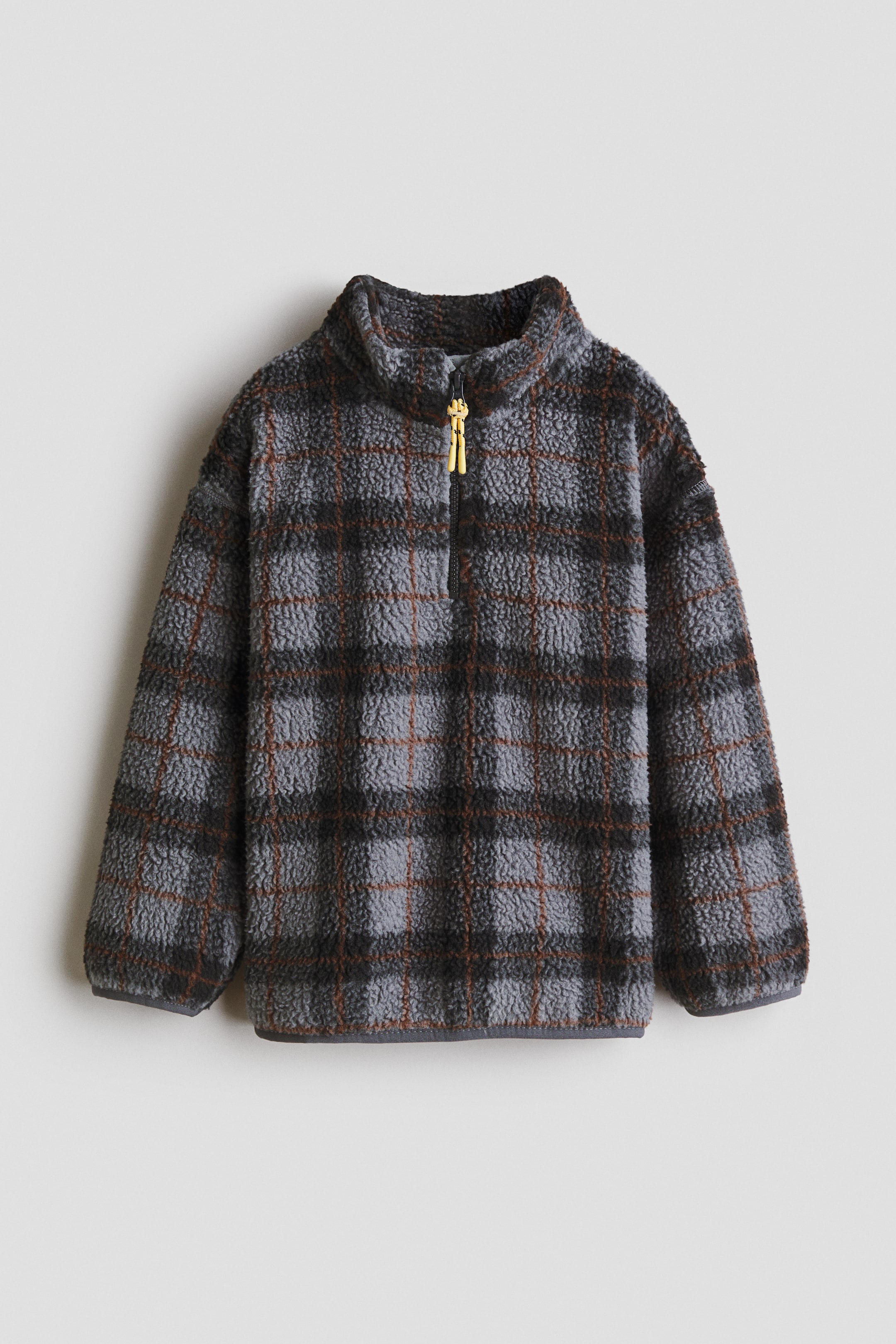 Größeres Bild anzeigen: Ein Fleece-Pullover mit Karomuster in Hellgrau-, Dunkelgrau- und Rostbrauntönen. Er verfügt über einen Stehkragen, lange Ärmel, einen schwarzen Half-Zip-Verschluss mit zwei kleinen goldfarbenen Reißverschlussanhängern sowie einen grau abgesetzten Saum.