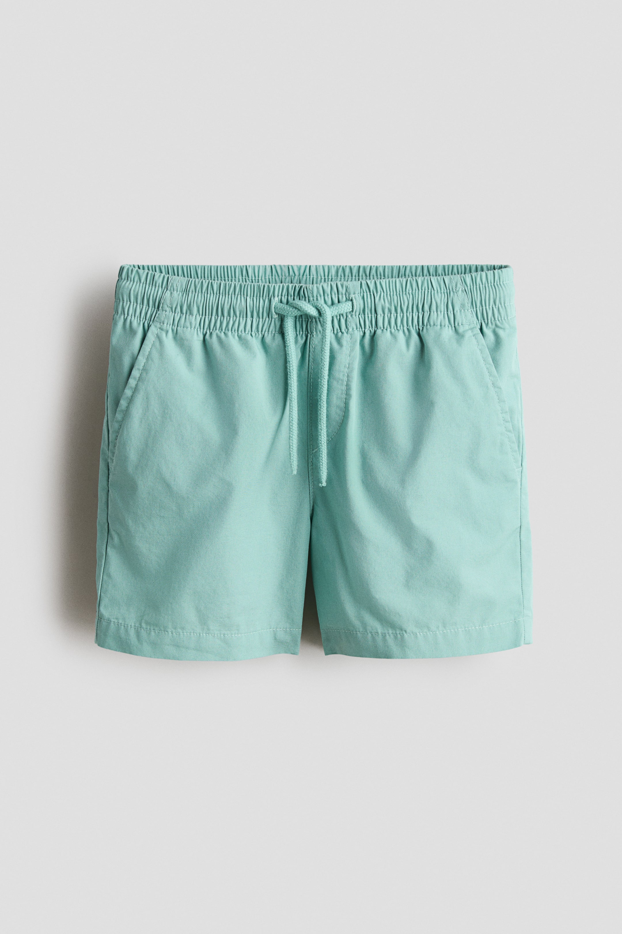View larger image: Mint green shorts showcase a gathered, elastic waistband with a drawstring and two front slash pockets.