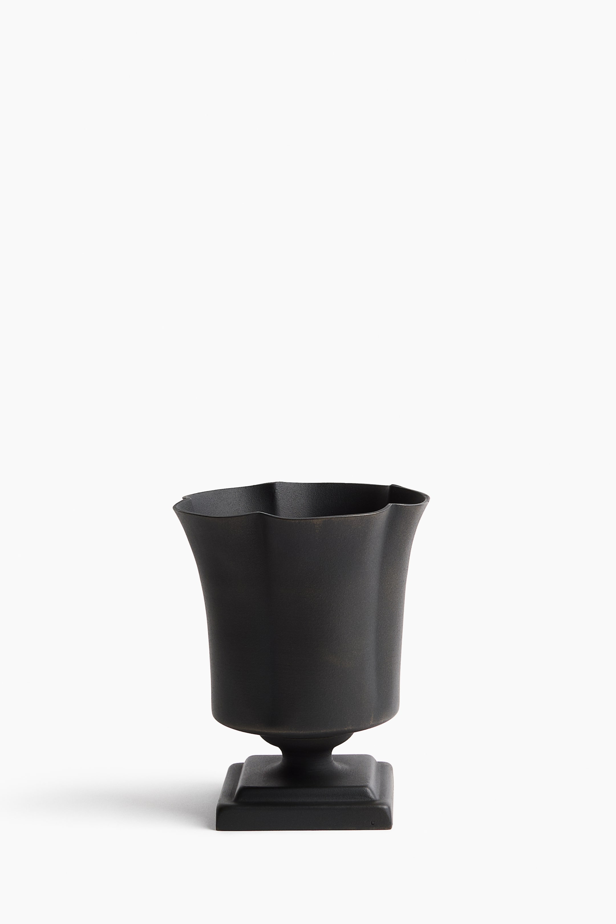 View larger image: A dark matte vessel is shown in a front view, featuring a flared, wavy rim and a tapering body, resting on a square pedestal base.