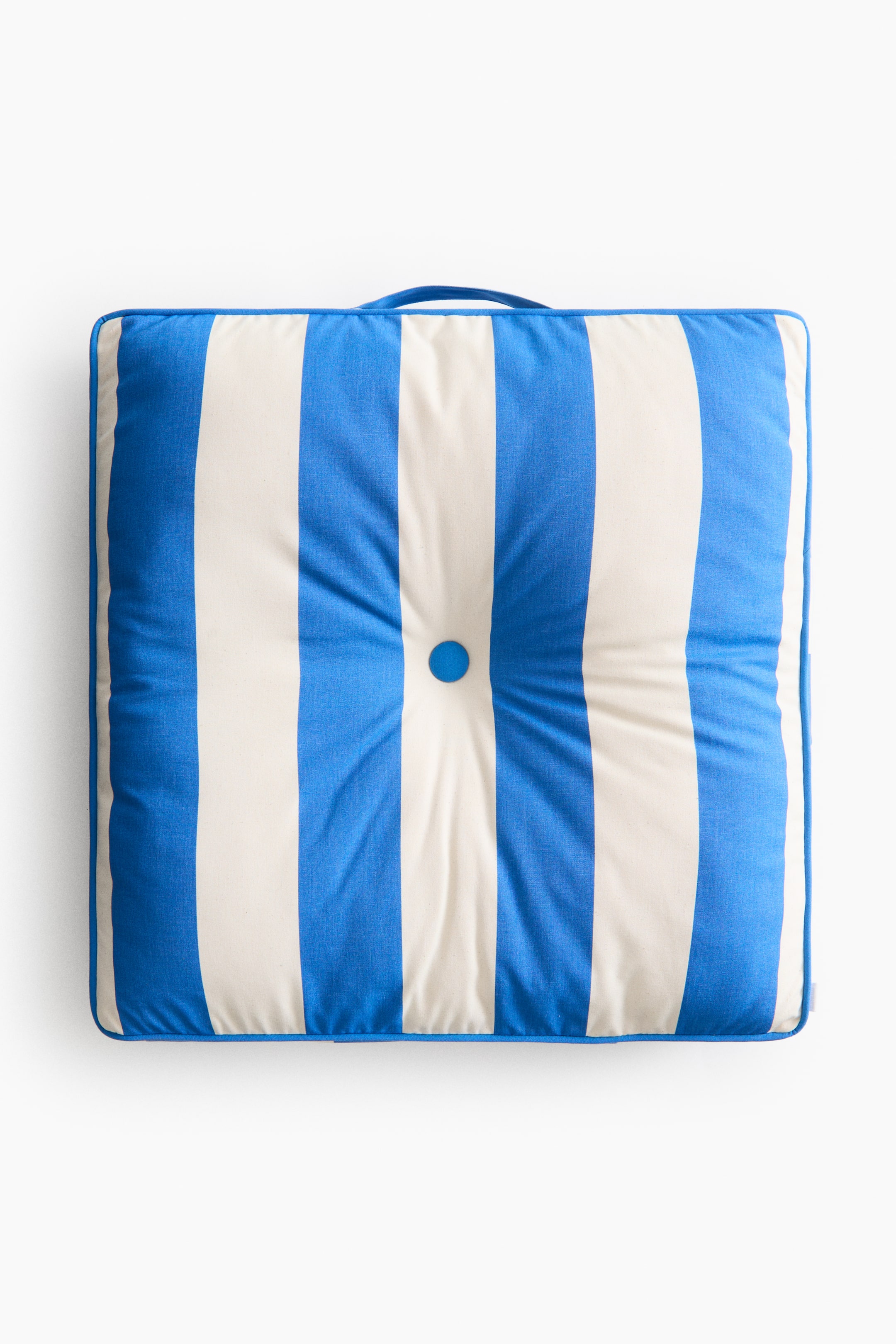 Ampliar la imagen: Un cojín cuadrado muestra un patrón de rayas verticales azules y blancas en su parte frontal. Presenta un botón central azul con capitoné que crea una hendidura, ribete azul a lo largo de los bordes y un asa de tela azul en la parte superior.
