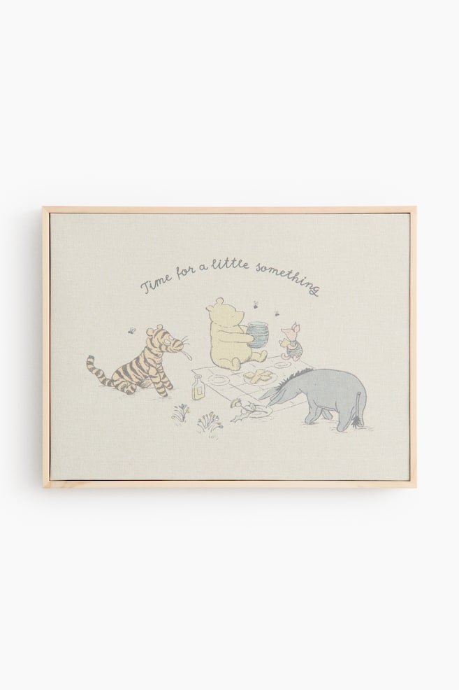 A framed canvas print featuring a light wooden frame and a beige canvas. The canvas displays a sketch-style illustration of Winnie the Pooh characters having a picnic, with the text "Time for a little something" curving above them. - 1