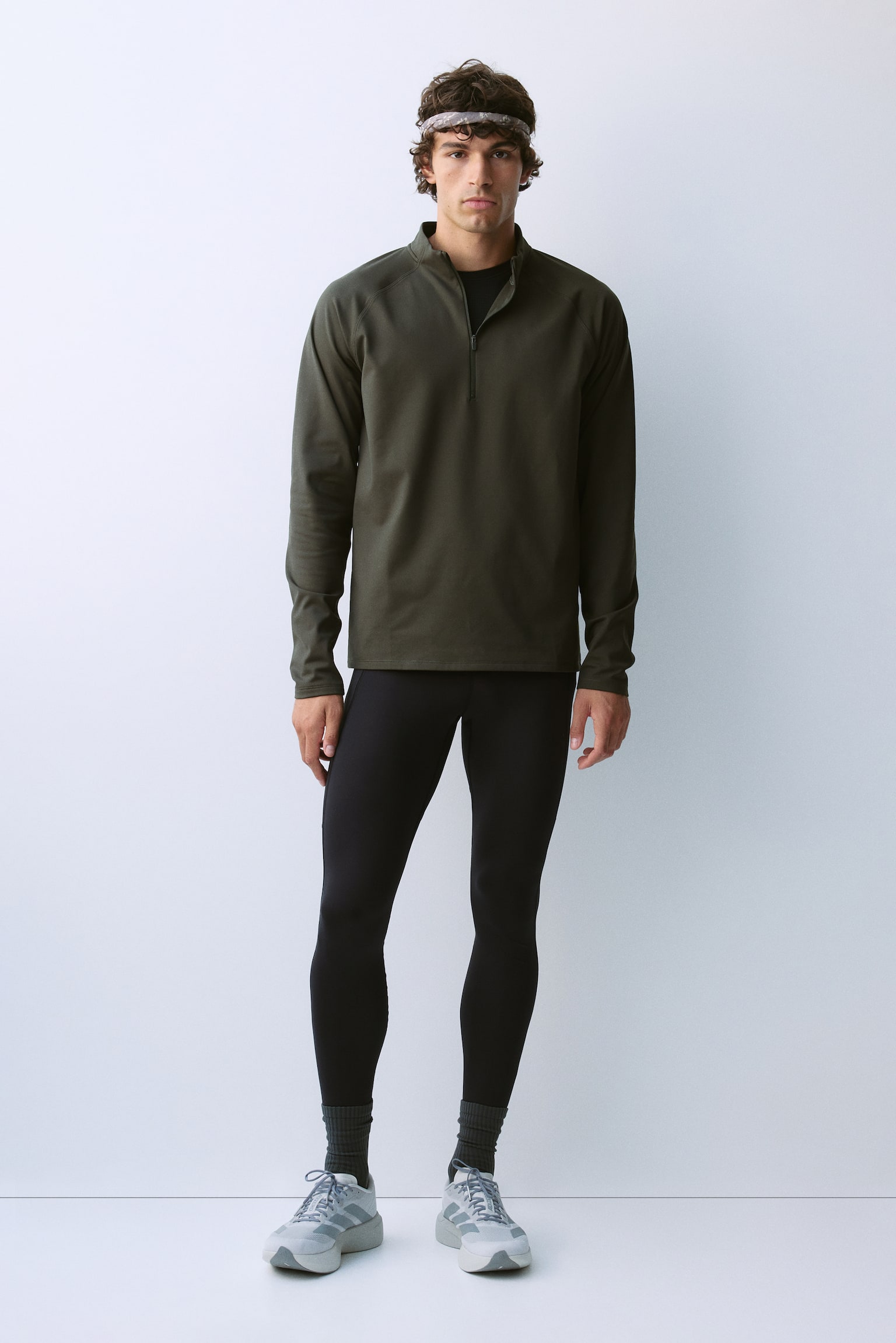These black leggings are presenting from the front, featuring a wide waistband and visible flatlock seams running down the sides. A small, rectangular pocket is visible on the upper left side, with a similar pocket appearing on the upper right side, and a subtle "MOVE" logo is marking the right thigh. - 1