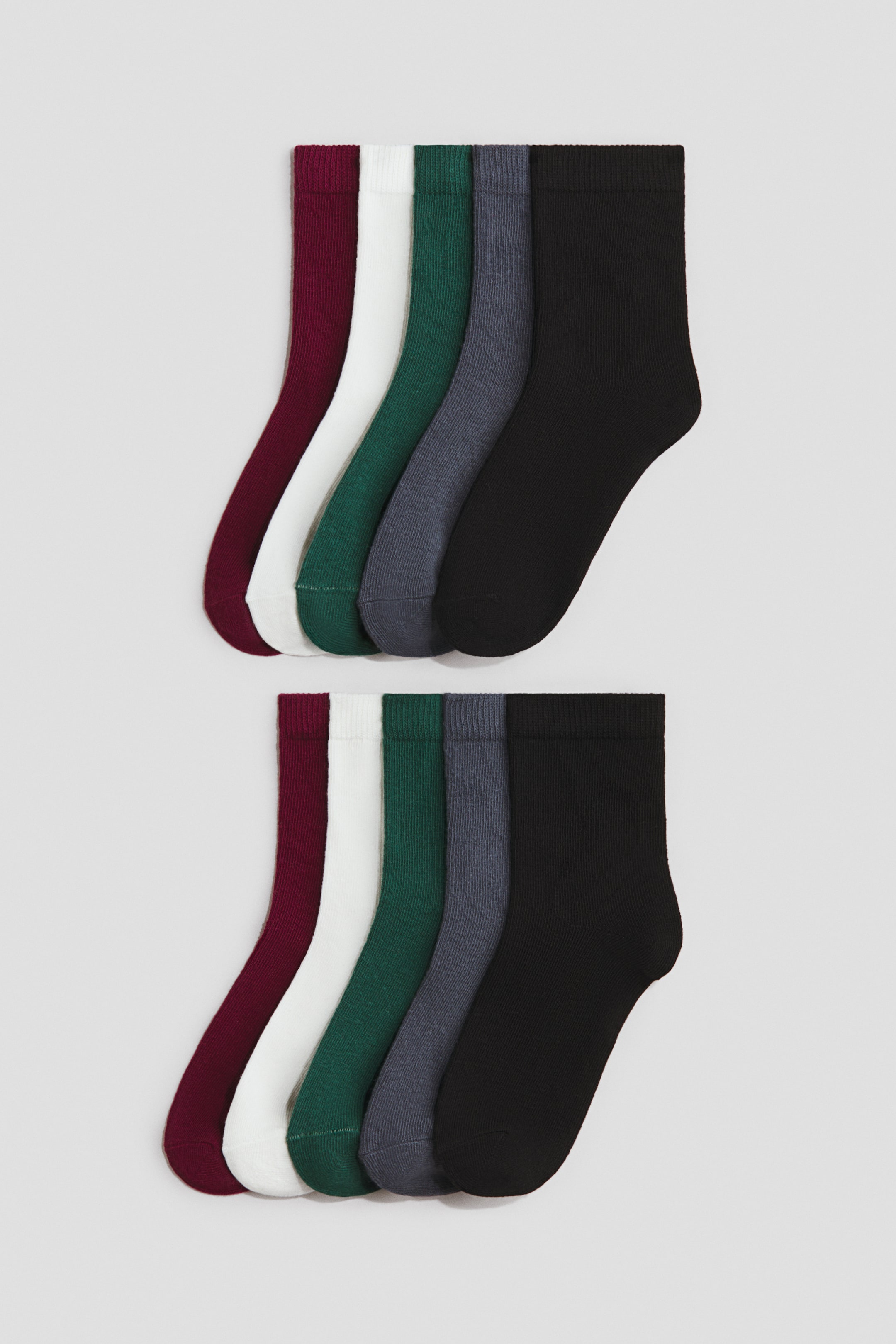 Größeres Bild ansehen: Zehn Paar Feinstricksocken liegen flach in zwei identischen, vertikal übereinander angeordneten Reihen zu je fünf Paaren und zeigen ihre Seitenansichten. Die Socken überlappen sich in einer Farbfolge aus Burgunderrot, Weiß, Dunkelgrün, Grau und Schwarz und betonen ihre gerippten, elastischen Bündchen.