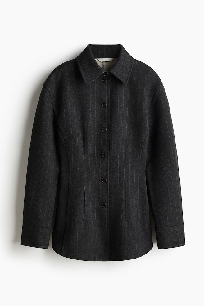 A dark grey pinstriped jacket is shown from the front, featuring a pointed collar and a six-button front closure. Long sleeves are extending, and vertical seams are shaping the waistline, ending in a curved hem. - 1