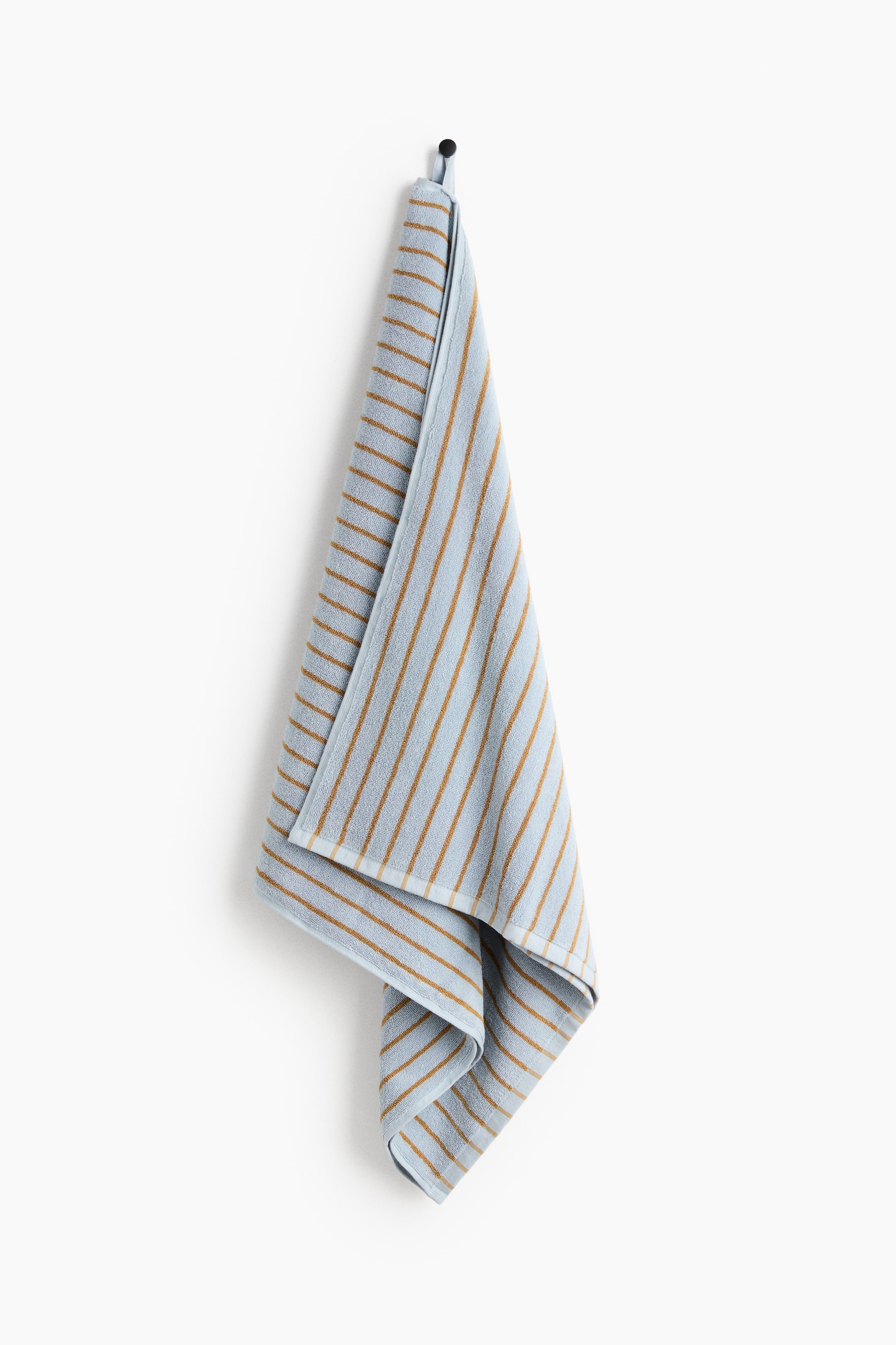 View larger image: A bath towel hangs, showing its front. It features a light-blue terry-cloth texture with thin, evenly spaced brown stripes running vertically along its length. A hanging loop is visible at the top of the towel.