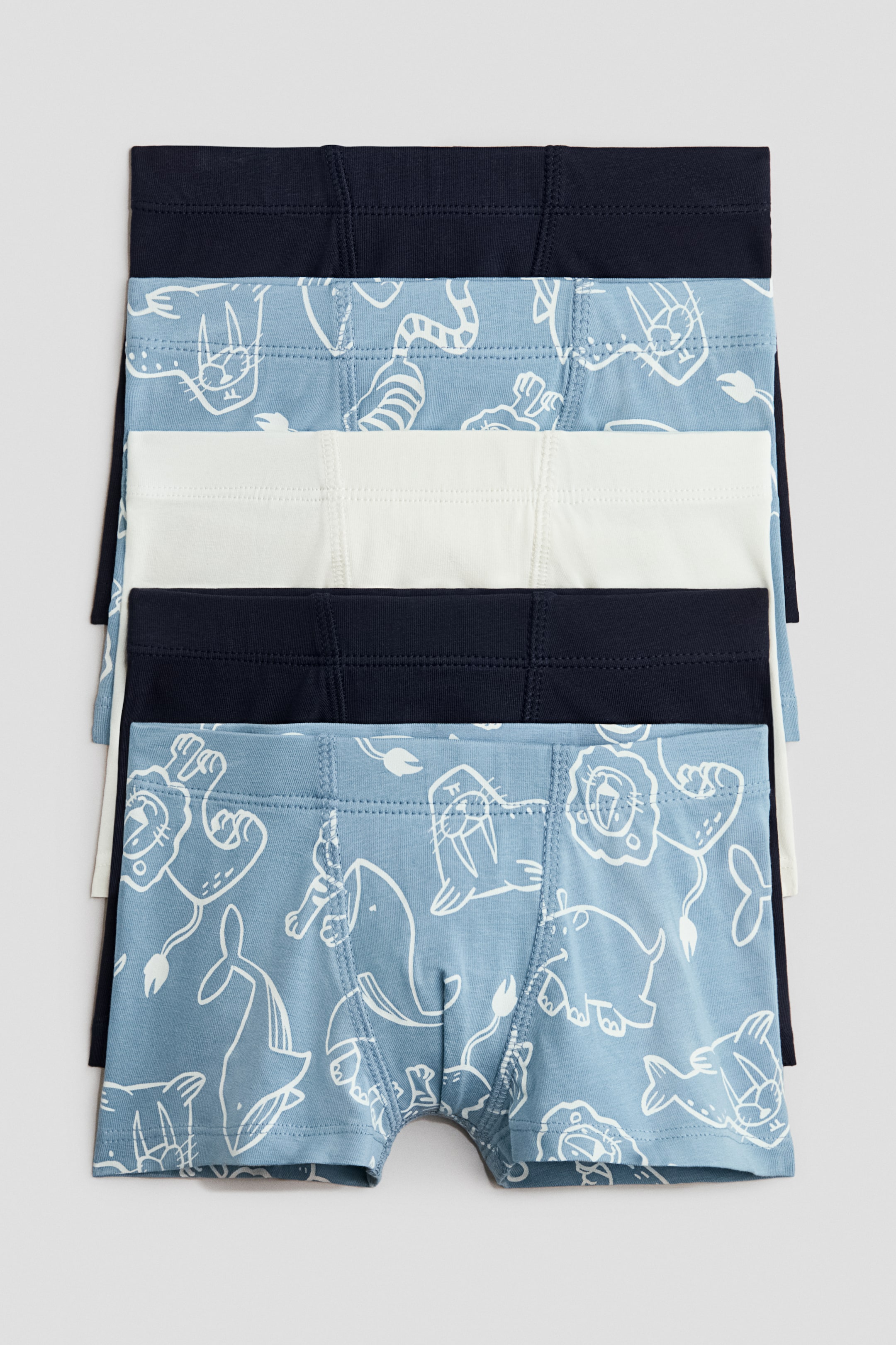 View larger image: Trunks in cotton jersey feature short legs, an elasticated waist, and a lined front, presented as a stack of five pairs. The pack displays two solid navy pairs, one solid white pair, and two light blue pairs with white outlined animal patterns, all facing front.