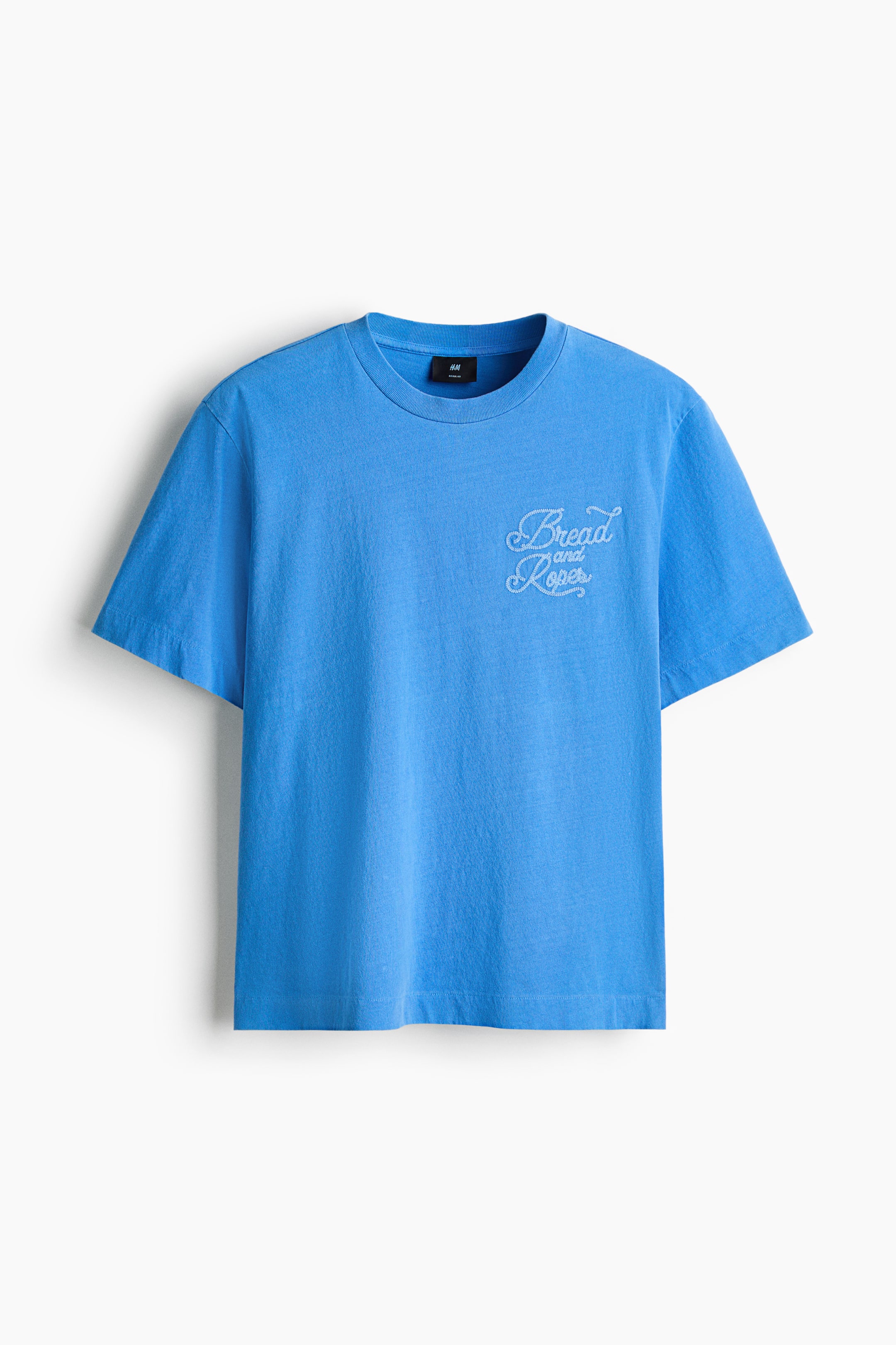 View larger image: A blue T-shirt crafted from heavyweight cotton jersey showcases its front, adorned with a white embroidered "Bread and Ropes" motif on the chest. It features a round, rib-trimmed neckline, dropped shoulders, and a straight-cut hem, providing a regular fit.