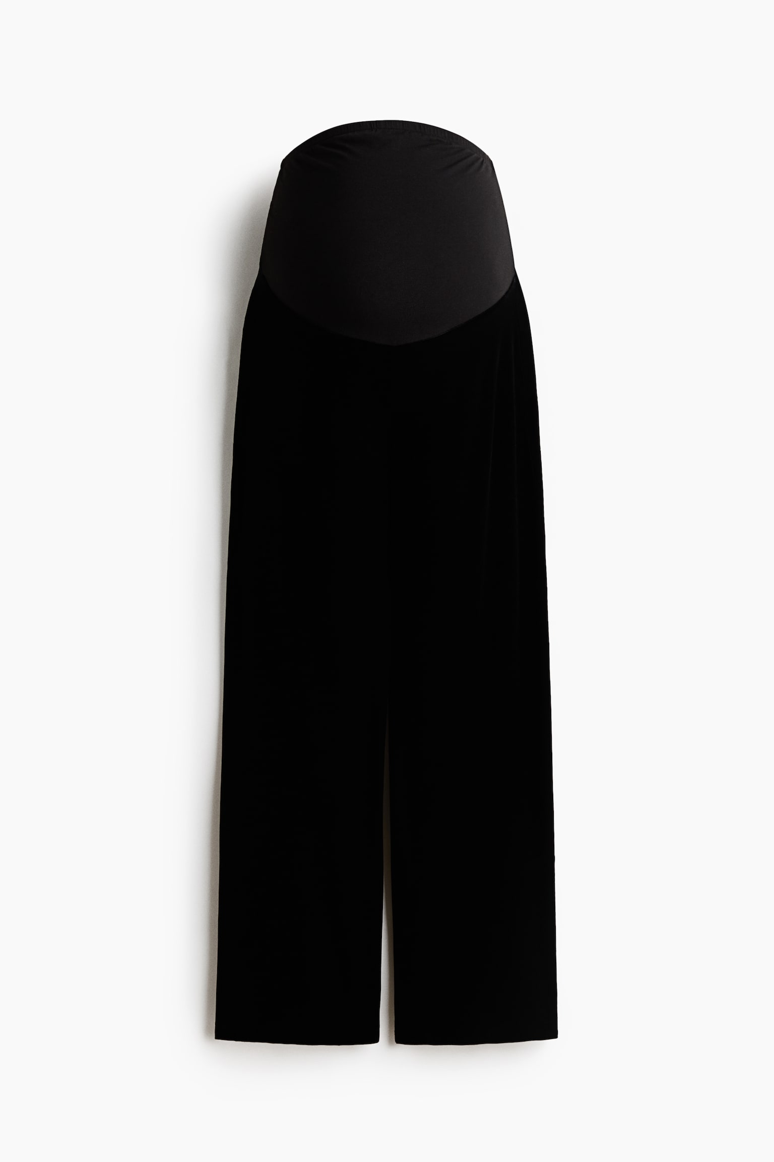 Pantalones de maternidad de pierna recta en color negro, mostrados de frente, con un amplio panel de cintura de punto elÃ¡stico diseÃ±ado para adaptarse sobre el vientre. Los pantalones presentan una silueta de pierna recta confeccionada en un tejido suave, tipo terciopelo.