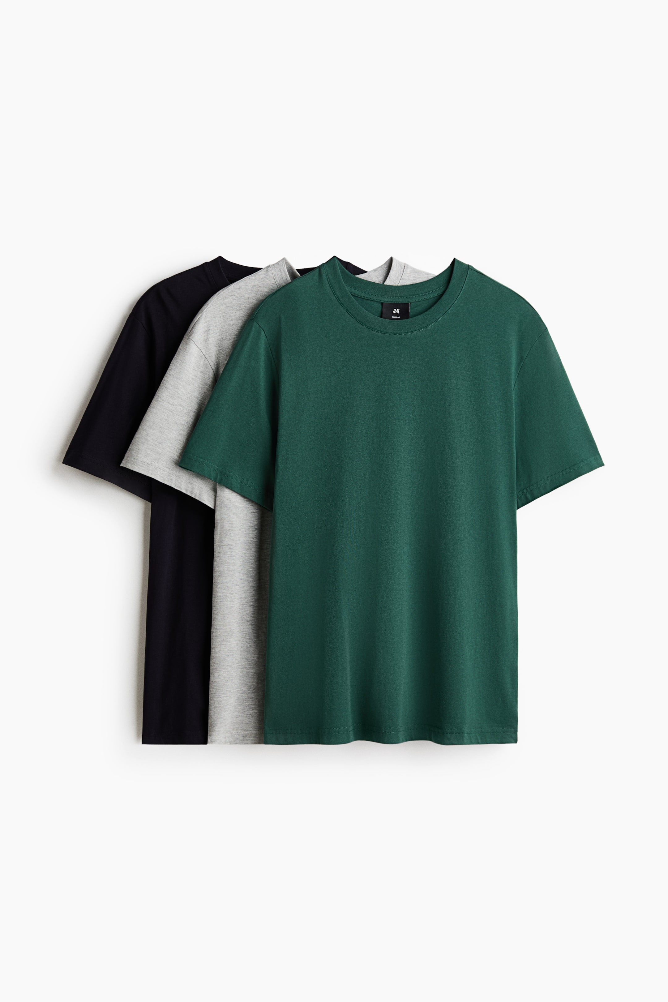 Visa större bild: Tre kortärmade t-shirts med rund halsringning är lagerlagda, med en mörkgrön tröja i förgrunden som delvis överlappar en ljusgrå tröja, vilken delvis överlappar en svart tröja. Varje t-shirt visar en avslappnad passform.