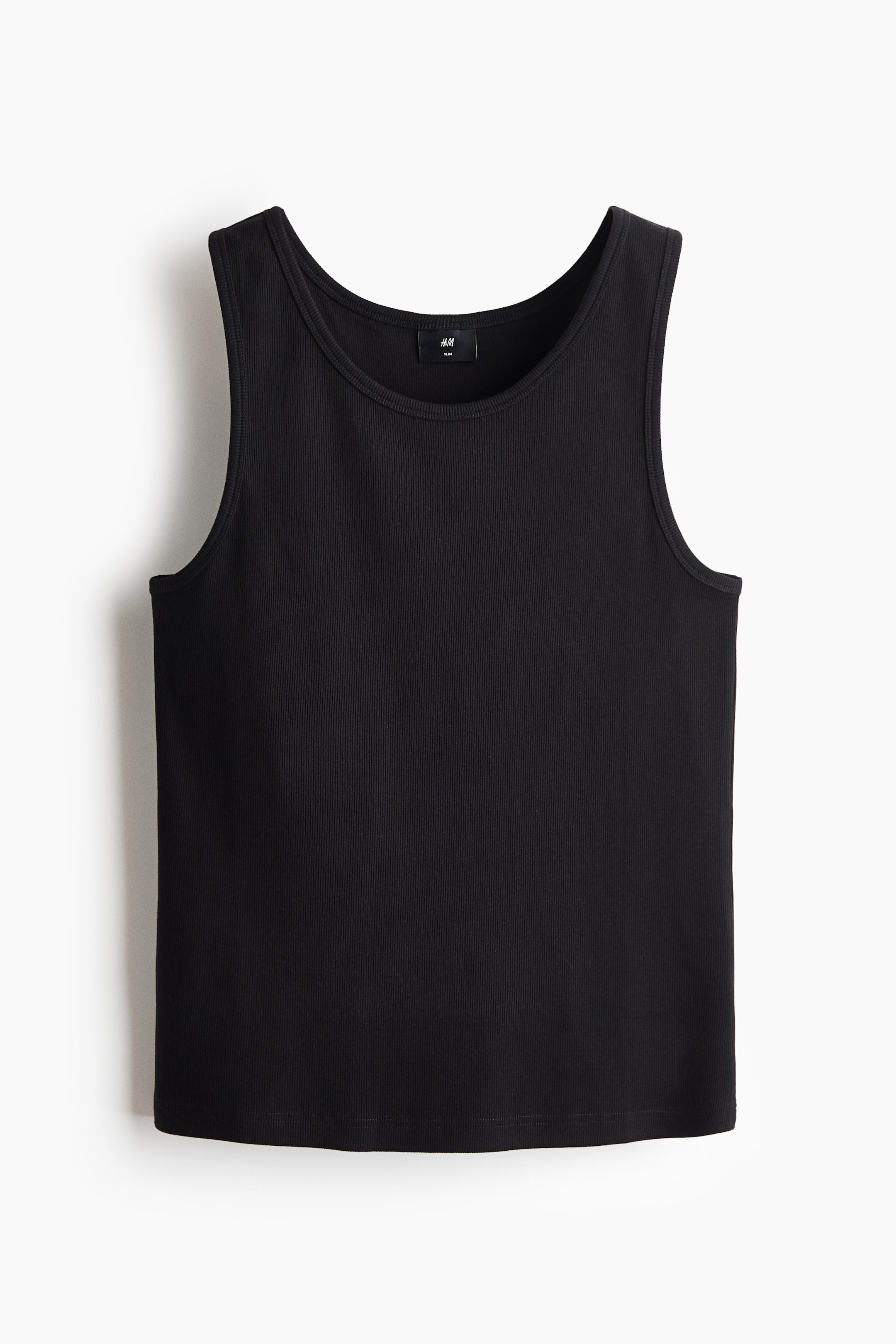 View larger image: "Slim-fit vest top dalam kain kapas berjalur. Top hitam ini ditampilkan dari depan, menonjolkan leher bulat, lubang lengan, dan kelim lurus, dengan tekstur berjalur menegak yang jelas kelihatan."