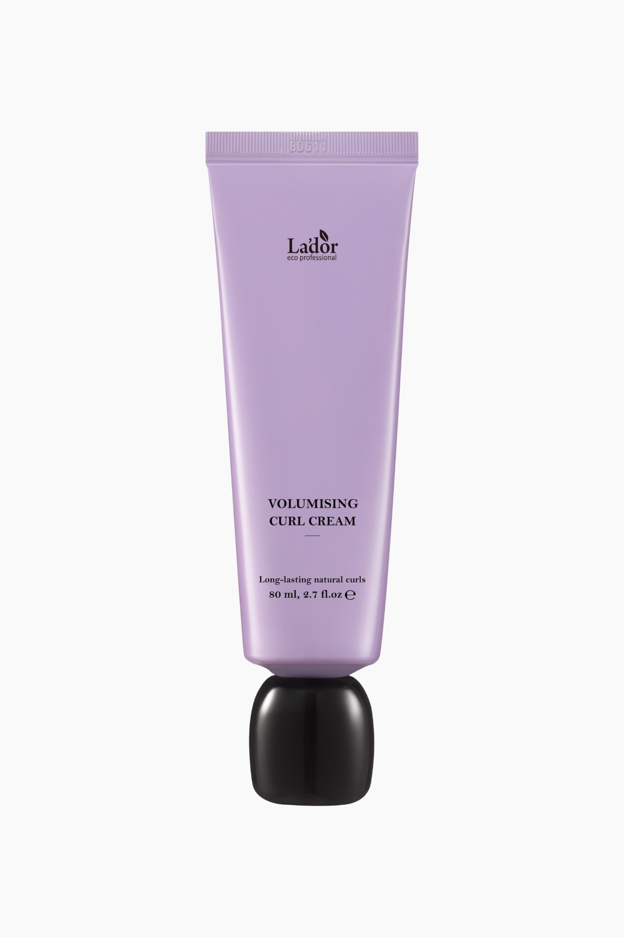 Se større billede: Et lys lilla rør af Lador Volumising Curl Cream står oprejst og vender fremad, med teksten 'Lador eco professional', 'Volumising Curl Cream', 'Langvarige naturlige krøller' og '80 ml, 2.7 fl.oz e' i sort skrift. Det har et bølget topstykke præget med 'BDG11' og hviler på en blank sort, afrundet hætte.