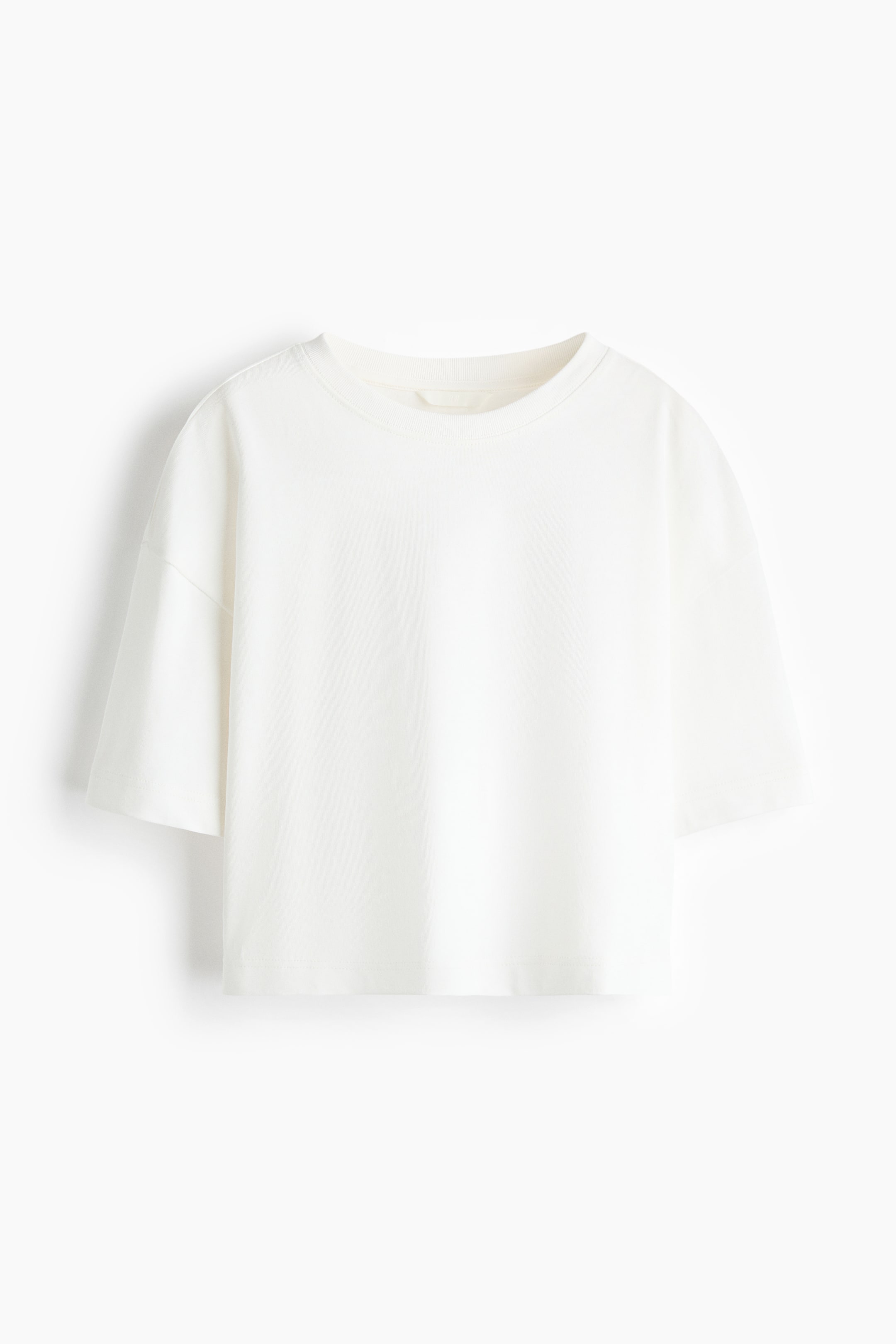 View larger image: An off-white boxy-style T-shirt crafted from soft cotton jersey, showcasing its front, features a loose fit, a crew neck, dropped shoulders, elbow-length sleeves, and a straight-cut hem.
