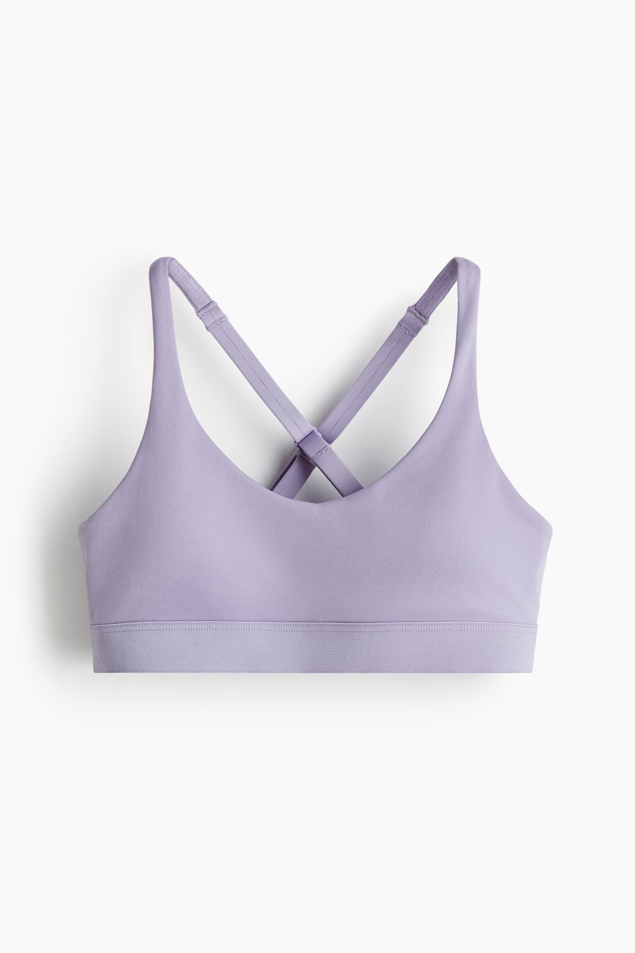 Grotere afbeelding bekijken: Een sporttop is van VOORAF gezien, toont een licht paarse kleur met een ronde halslijn en een brede elastische onderband. De verstelbare kruislingse bandjes zijn zichtbaar aan de achterkant.