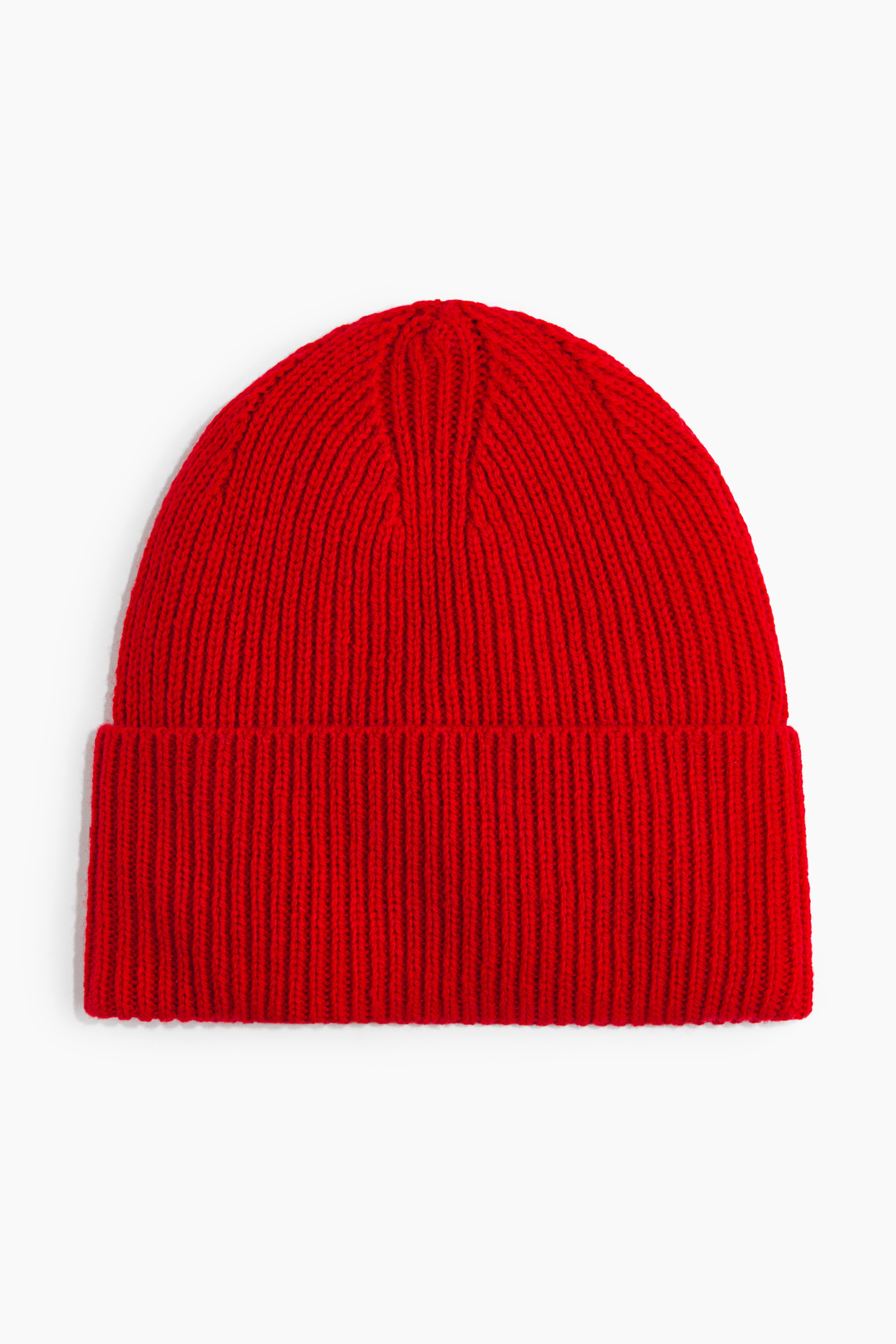 A bright red beanie in a soft rib-knit with a folded turn-up hem is being worn by the model. The beanie is positioned high on the head and coordinates with a red collared shirt.