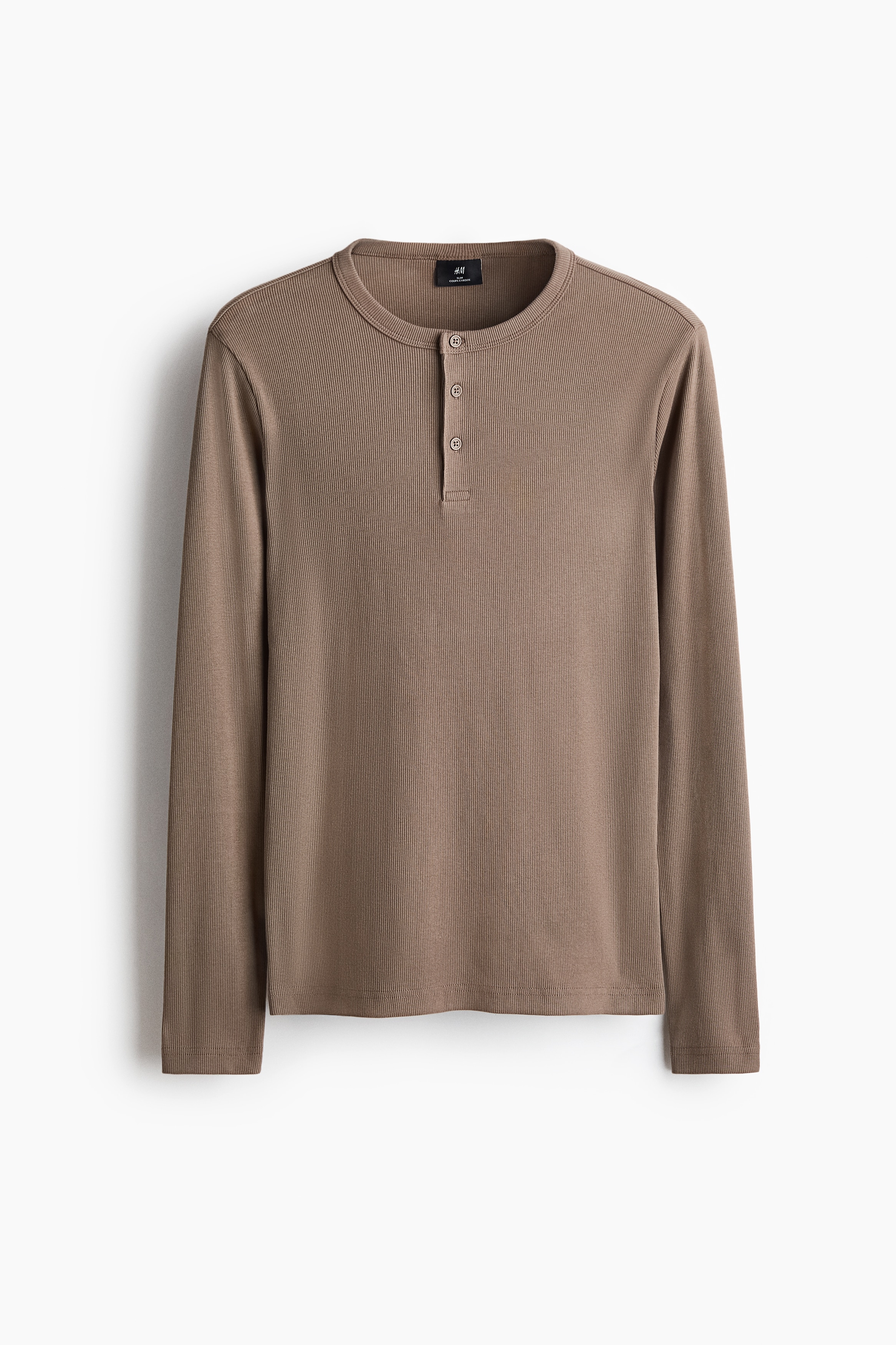 Un haut en tricot cÃ´telÃ© taupe Ã  manches longues est portÃ© par le mannequin, rentrÃ© dans un jean bleu dÃ©lavÃ© clair. Le haut prÃ©sente une coupe ajustÃ©e, un col rond avec patte de boutonnage et des Ã©paules tombantes.