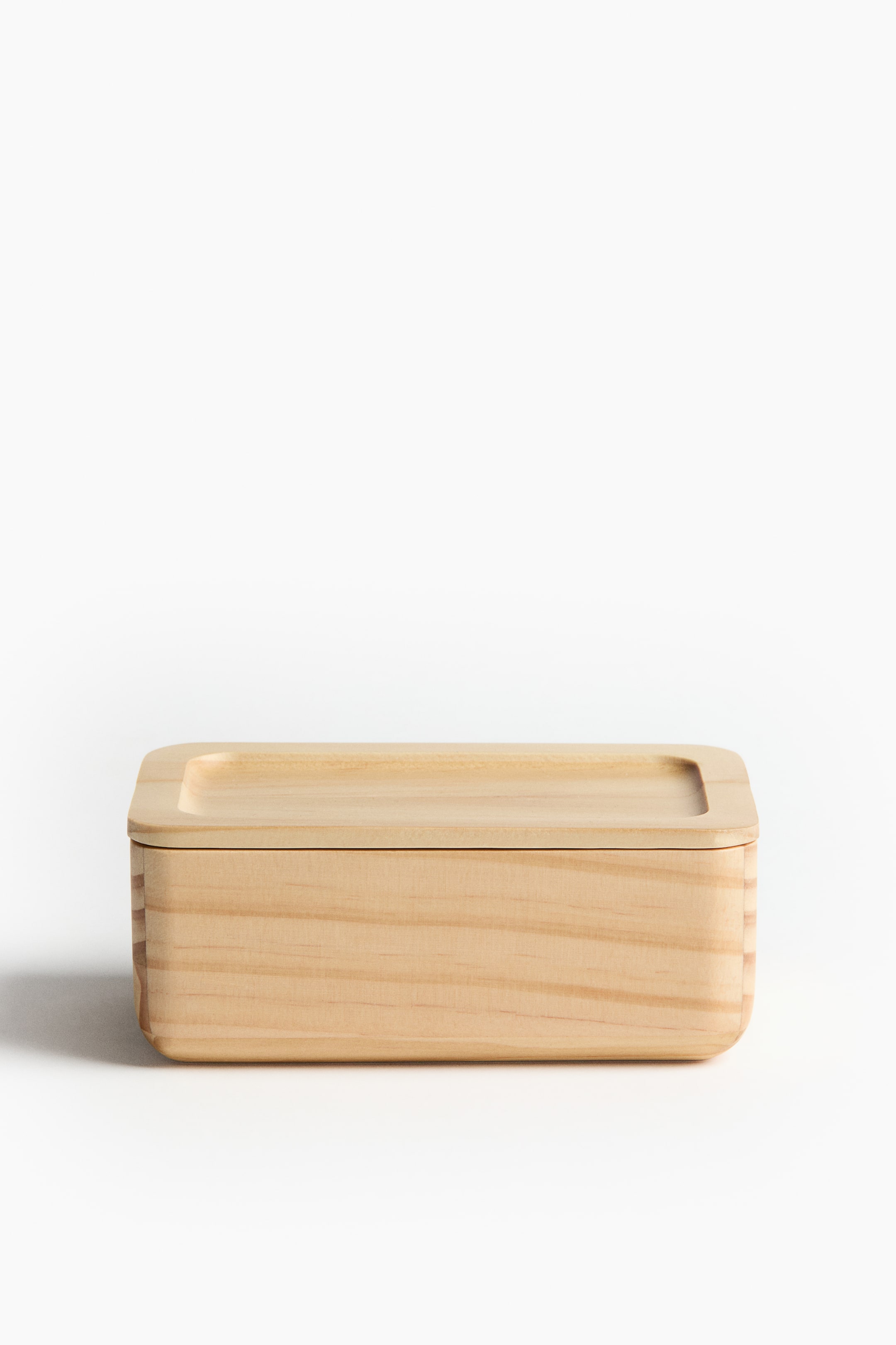 View larger image: A light-toned wooden rectangular box with visible grain and rounded corners is facing front. A flat wooden lid with a raised, recessed rectangular top surface is covering the box.