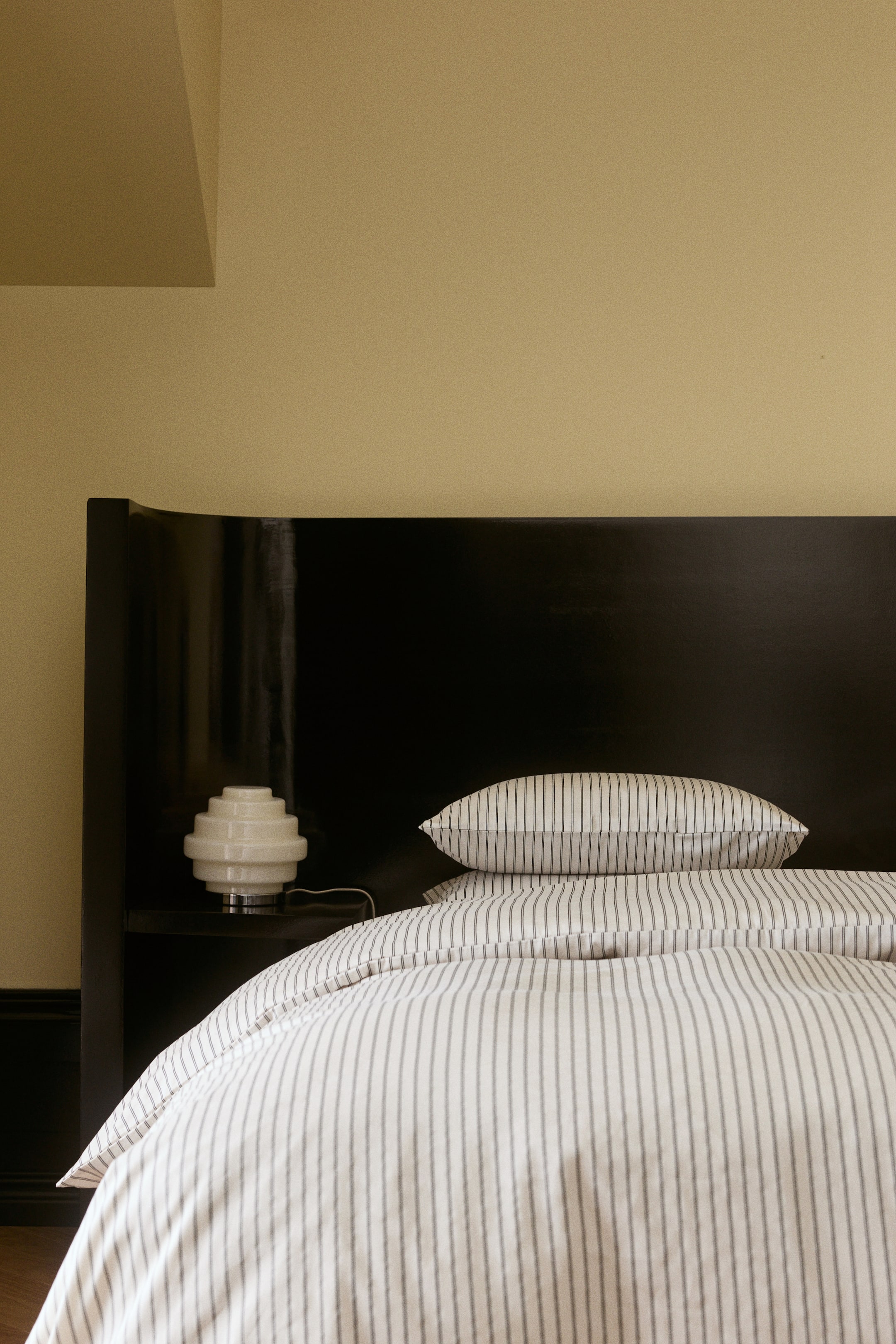 Voir une image plus grande: Un ensemble de housse de couette pour lit simple en satin de coton léger, orné d’un fin motif à rayures verticales foncées, est drapé sur un lit. Une taie d’oreiller assortie à rayures repose sur le dessus, mettant en valeur le design coordonné de l’ensemble de literie.