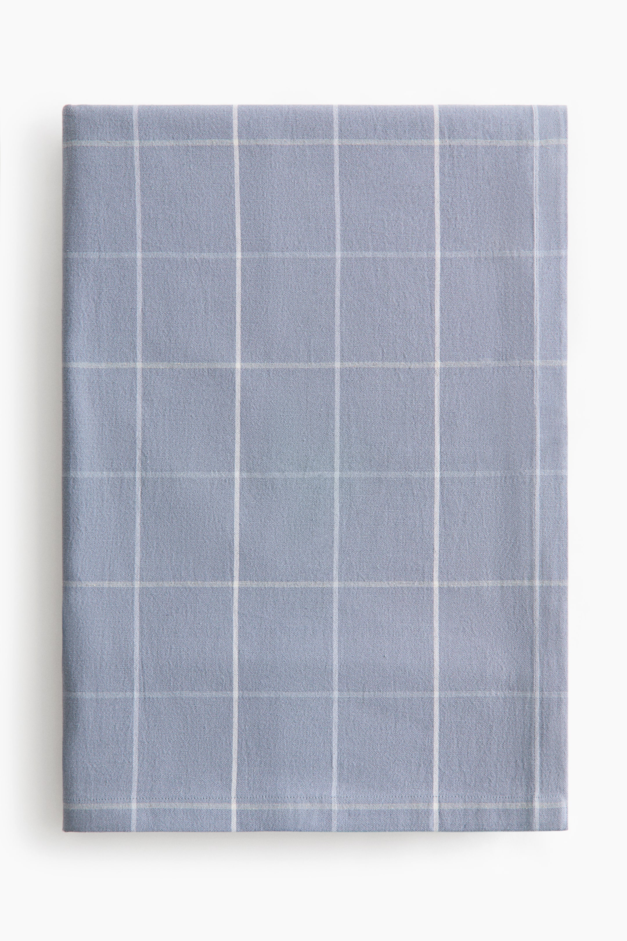 View larger image: The tablecloth in a soothing light blue shade is displayed prominently, folded into a neat rectangle. It showcases a classic white yarn-dyed grid pattern and is elegantly finished with a visible folded hem along the bottom edge.