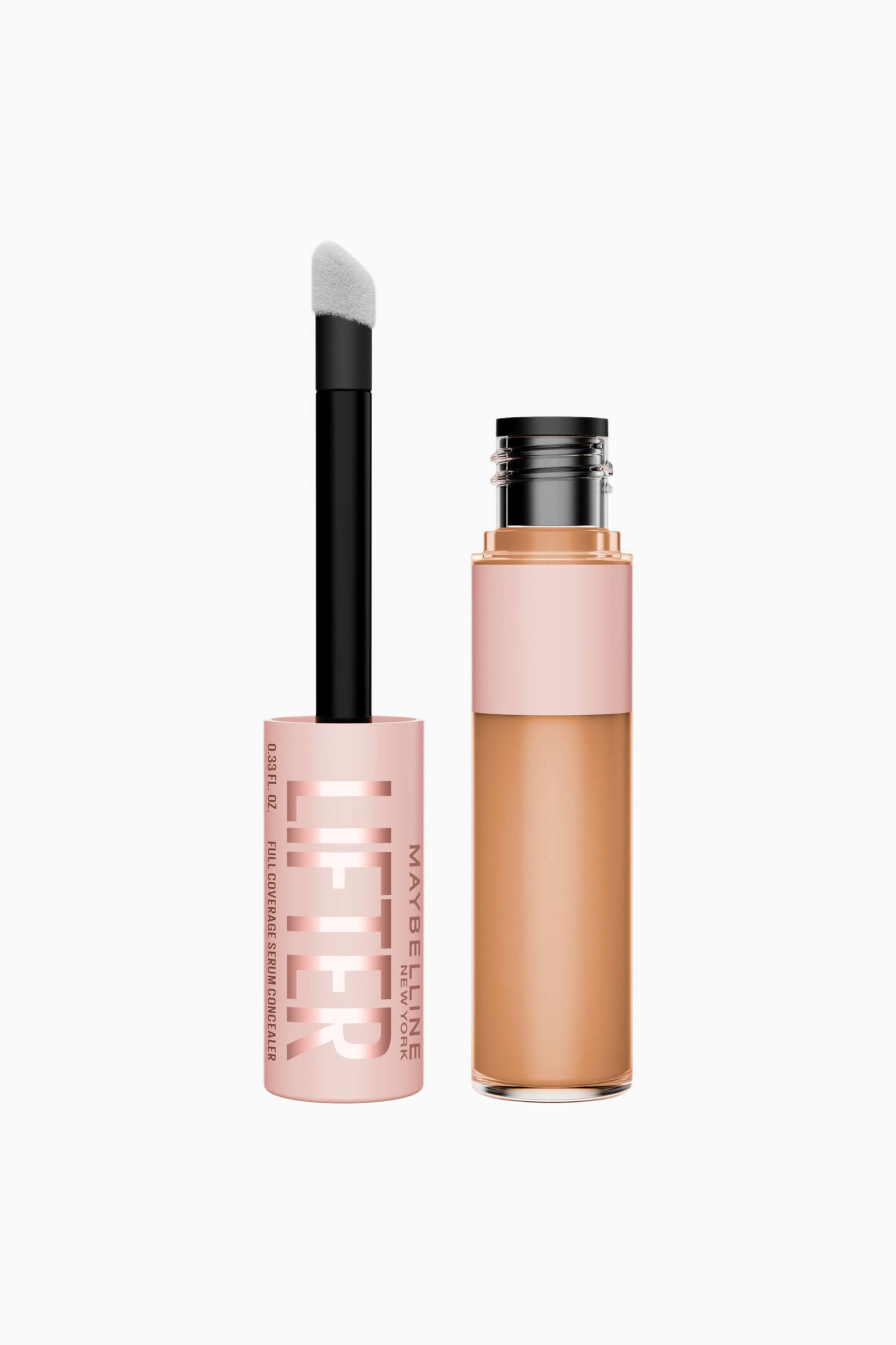 Näytä suurempi kuva: Maybelline Lifter Full Coverage Serum Concealer esittelee osiaan: läpinäkyvä, sylinterimäinen tuubi, joka on täytetty vaaleanruskealla nestemäisellä tuotteella. Tuubissa on vaaleanpunainen korkki, jossa on ruusukullanväristä tekstiä, ja irrotetussa applikaattorissa näkyy musta varsi sekä valkoinen, flockattu doe-foot.