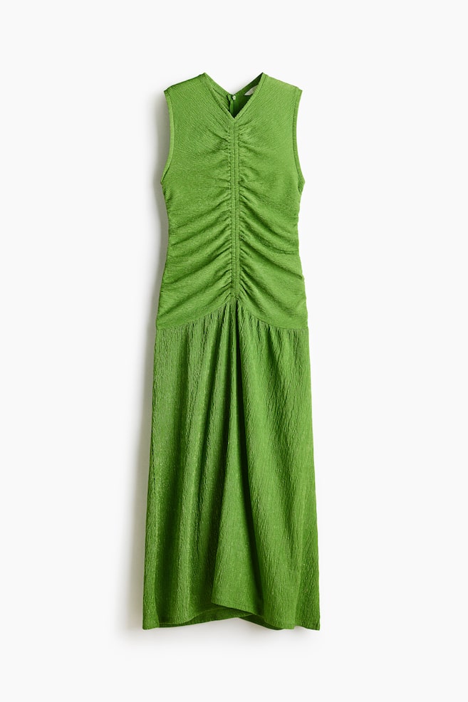 Una vista frontal de un vestido midi verde sin mangas que presenta un escote en V y un cuerpo fruncido, todo confeccionado en un tejido con textura arrugada. - 1