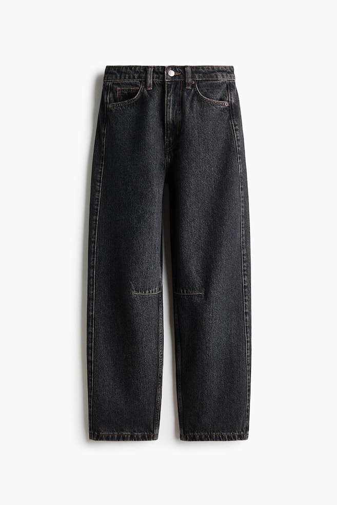 A pair of high-waisted, five-pocket jeans in a dark grey washed denim is hanging flat from a front view, displaying a curved, voluminous leg silhouette that tapers toward the hem. The design features a classic zip fly with a silver-tone button closure and horizontal seams detailing the knees. - 1