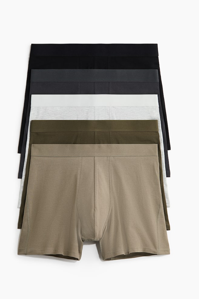 Fünf Paar Herren-Boxershorts sind gestapelt und zeigen von oben nach unten die Farben Schwarz, Dunkelgrau, Hellgrau, Olivgrün und Beige. Jedes Paar verfügt über einen elastischen Bund und eine genähte Fronttaschenkonstruktion. - 1