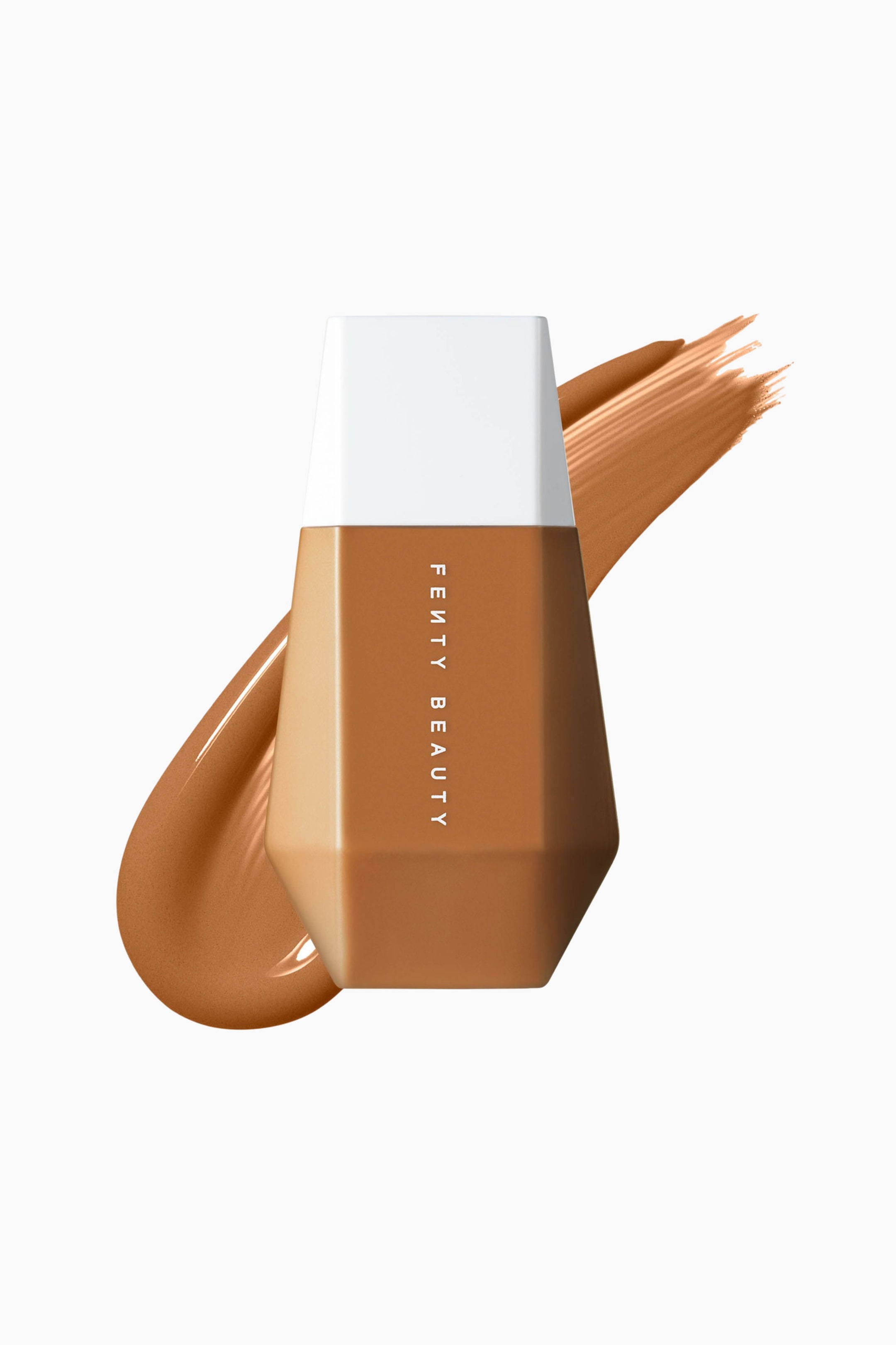 Visa större bild: En geometrisk, facetterad flaska med Fenty Beauty Eaze Drop Blurring Skin Tint står upprätt och visar sin framåtvända fasett med vertikal vit branding och en vit trapetsformad kork. Bakom flaskan sveper ett tjockt, diagonalt prov av den matchande medium-djupa, solbruna flytande makeupen från nedre vänstra till övre högra hörnet.