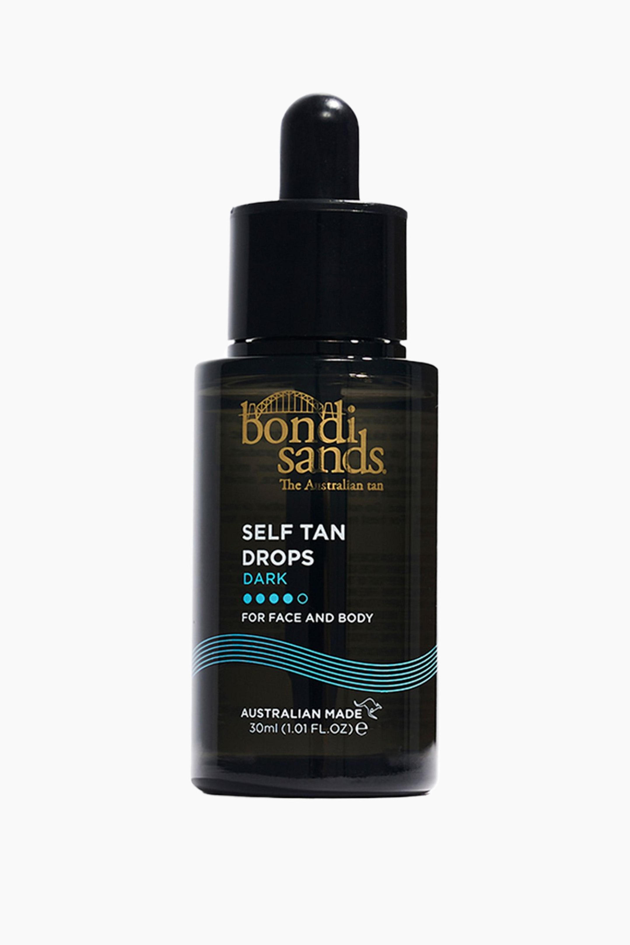 Vis større bilde: En mørk glassflaske med Bondi Sands selvbruningsdråper står oppreist og vendt fremover. Den har en svart dråpetopp og en etikett som viser "Bondi Sands" i gull, "Self Tan Drops Dark" i hvitt med fire blå prikker, "For Face and Body," og volumet "30ml" i hvitt, fremhevet av blå bølgete linjer.