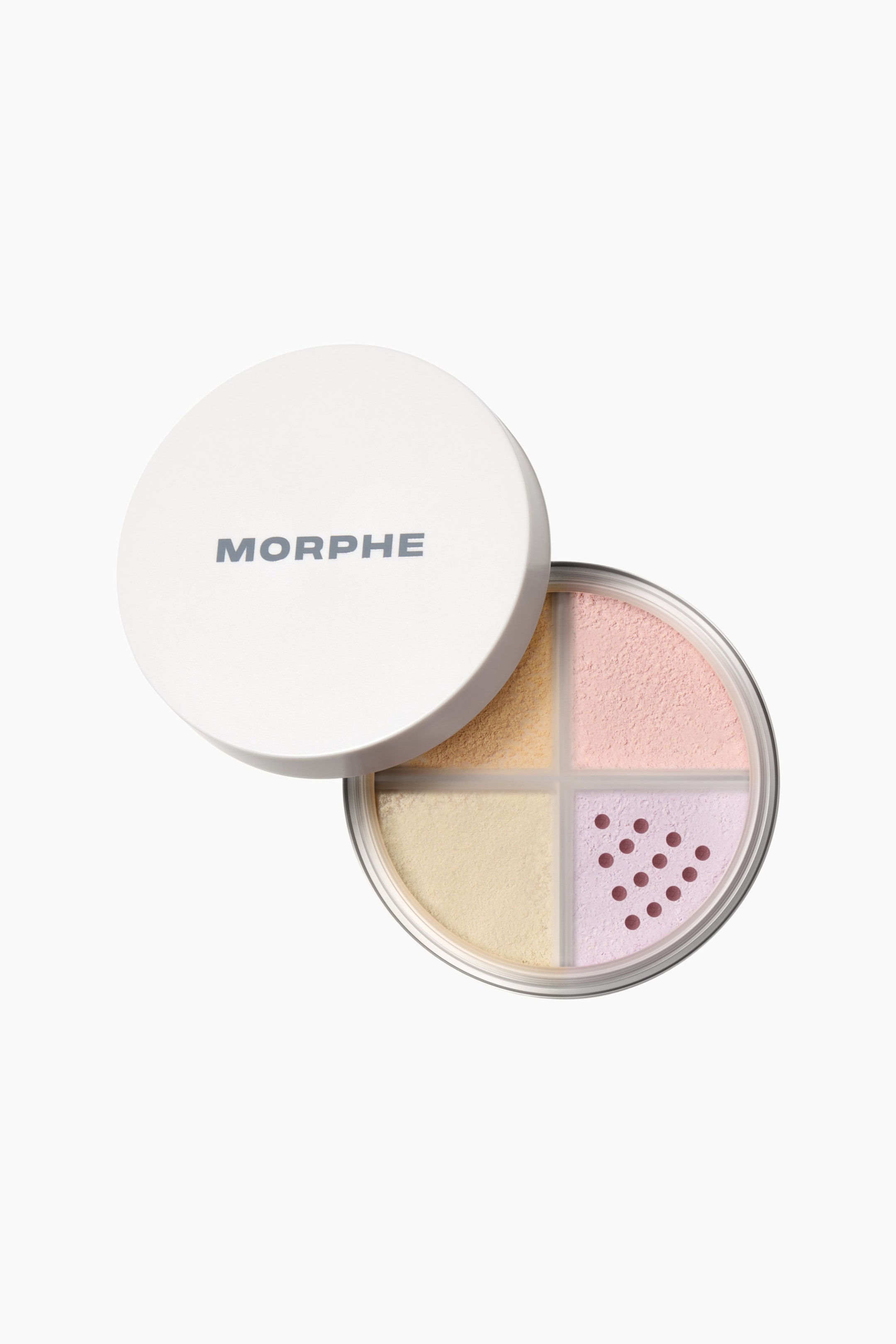 Visa större bild: Morphe Bake & Set Loose Powder Quad visas i en rund, genomskinlig behållare som är indelad i fyra fält med löst puder i pastelltoner av gult, rosa, kräm och lavendel. Ett vitt lock med ”MORPHE”-logotypen ligger delvis förskjutet åt vänster och blottar facken undertill, där lavendelfacket visar ett triangulärt mönster av silhål.