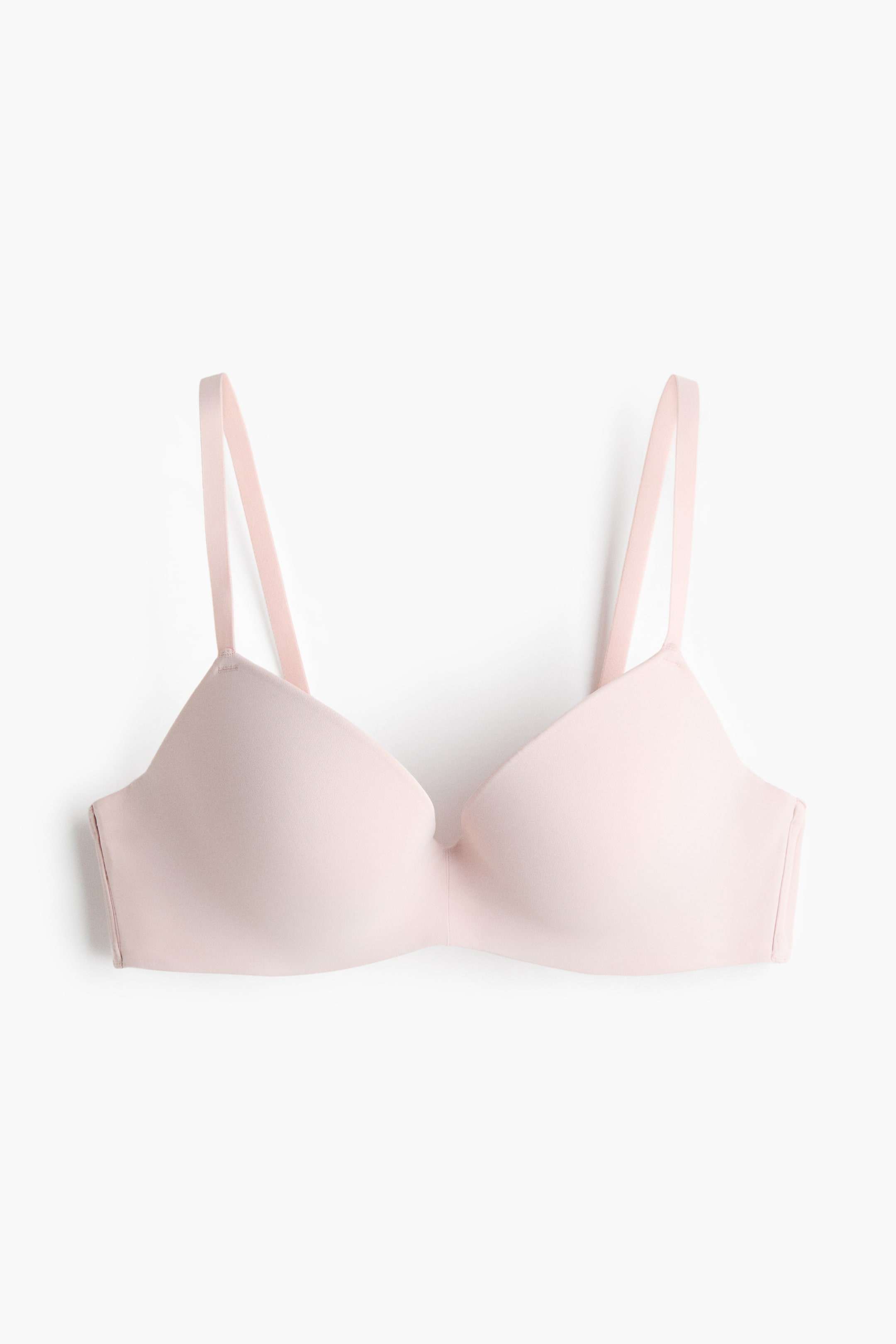 View larger image: A light pink push-up bra in microfibre is showcased facing front, featuring smooth padded cups and thin adjustable shoulder straps.