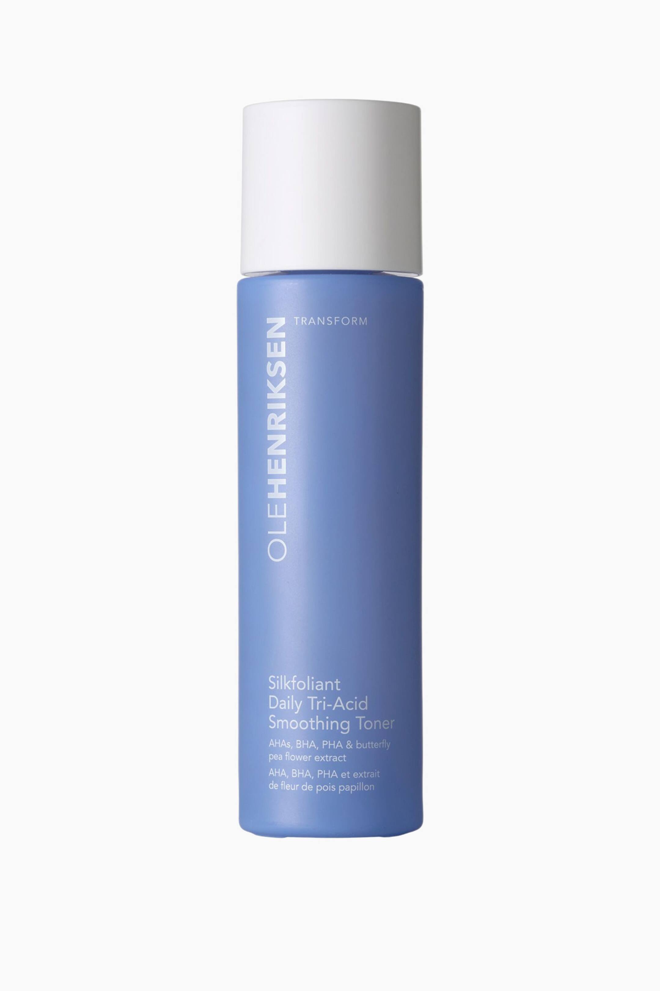 Visa större bild: En flaska Olehenriksen Silkfoliant Daily Tri-Acid Smoothing Toner står upprätt och vänd framåt. Den har en dämpad blå cylindrisk kropp med ett vitt cylindriskt lock och visar varumärkesnamnet och produktinformationen på framsidan.