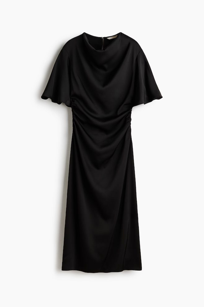 Un vestido midi negro, mostrado de frente, presenta un escote drapeado tipo cowl y mangas cortas fluidas con vuelo. El diseÃ±o muestra fruncidos a lo largo de los laterales de la cintura que crean suaves pliegues drapeados por el centro del cuerpo y la falda. - 1