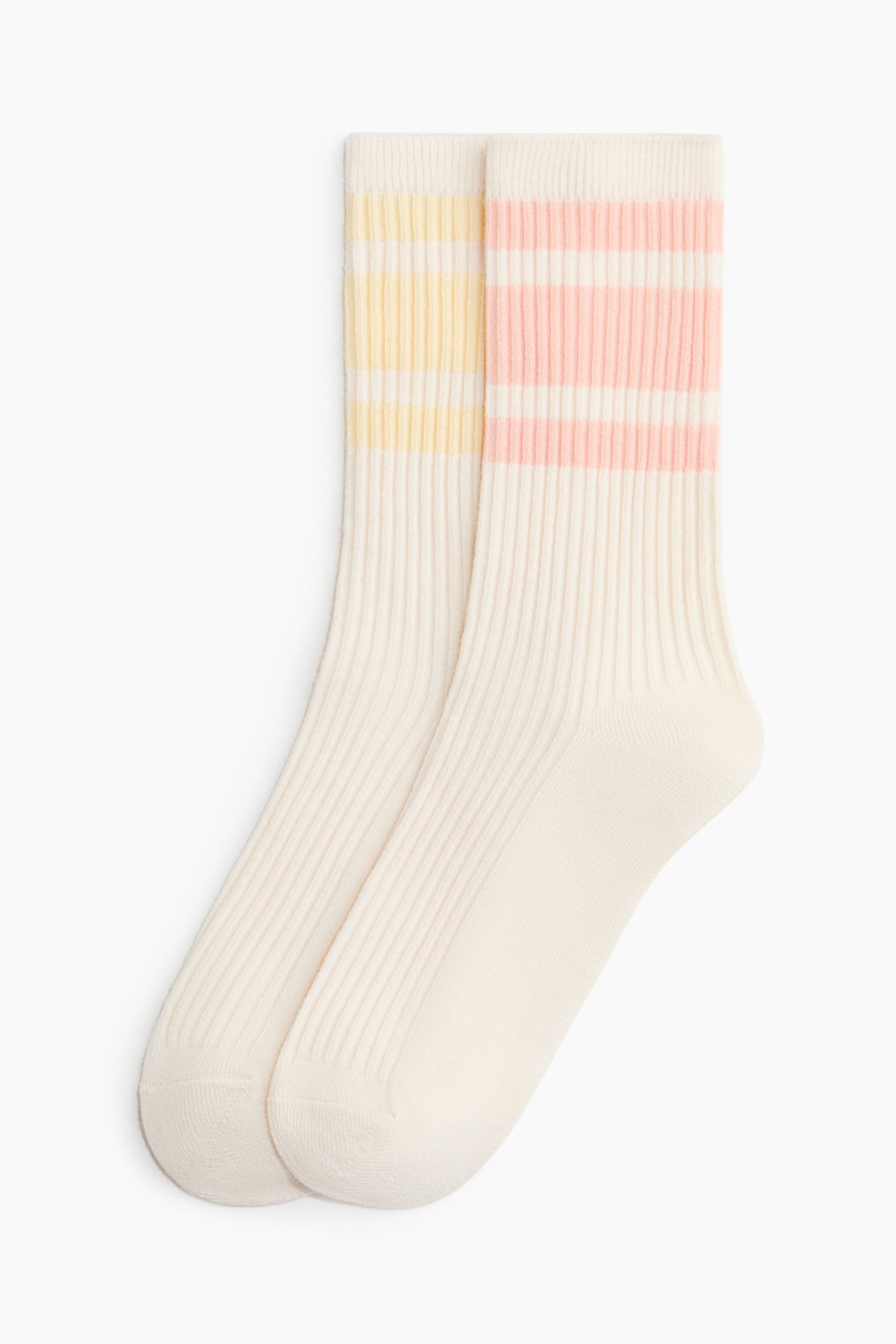 Ingrandisci l'immagine: Un paio di calze morbide, color bianco sporco, in misto cotone a coste, presentate frontalmente, con bordi elasticizzati. Una calza mostra tre strisce gialle vicino alla parte superiore, mentre l'altra calza presenta tre strisce rosa vicino alla parte superiore.