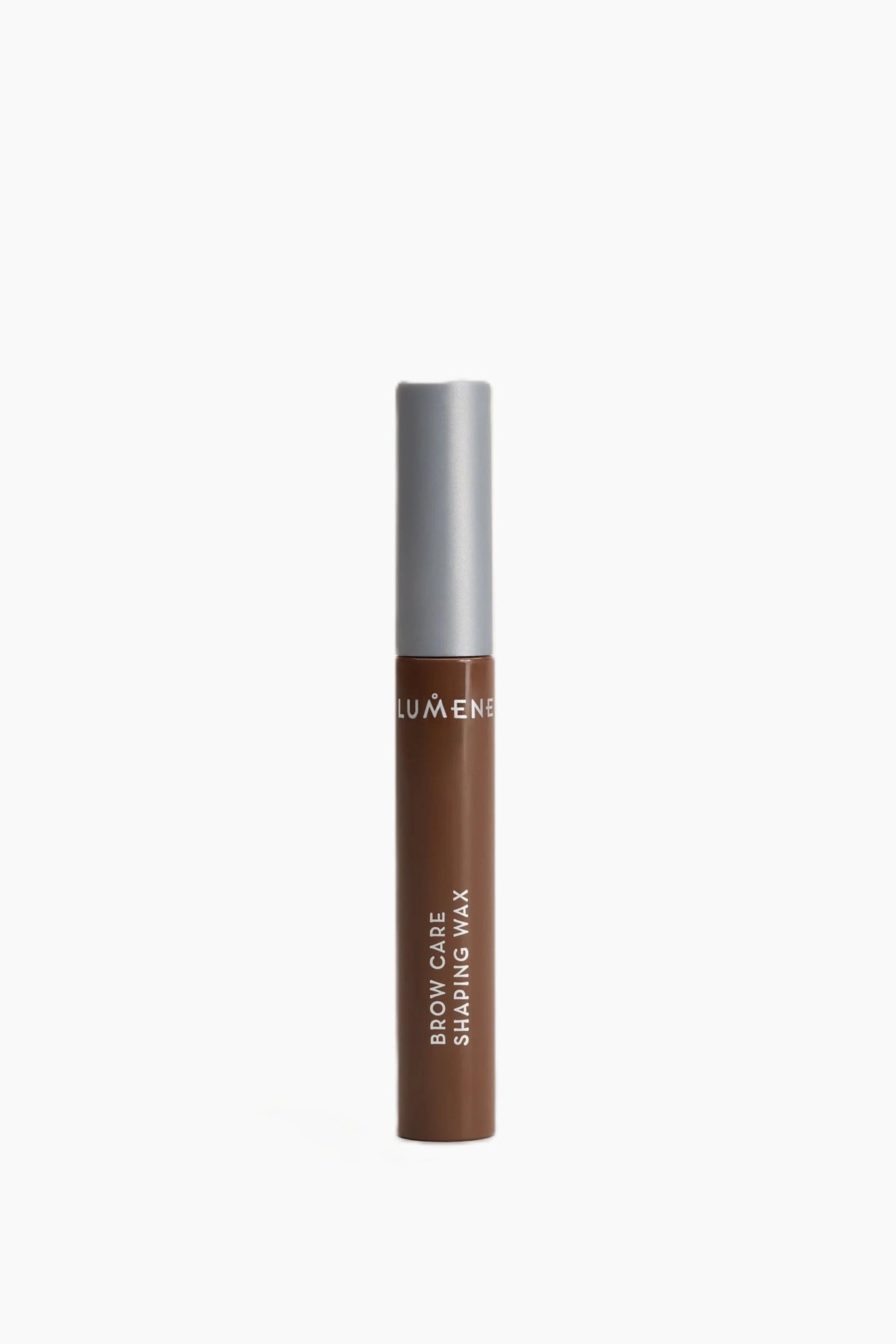 Visa större bild: Ett brunt rör av Lumene brow care shaping wax står upprätt, med ett silverlock. Vit text syns på den bruna kroppen, där det står "Lumene," "Brow Care," och "Shaping Wax."