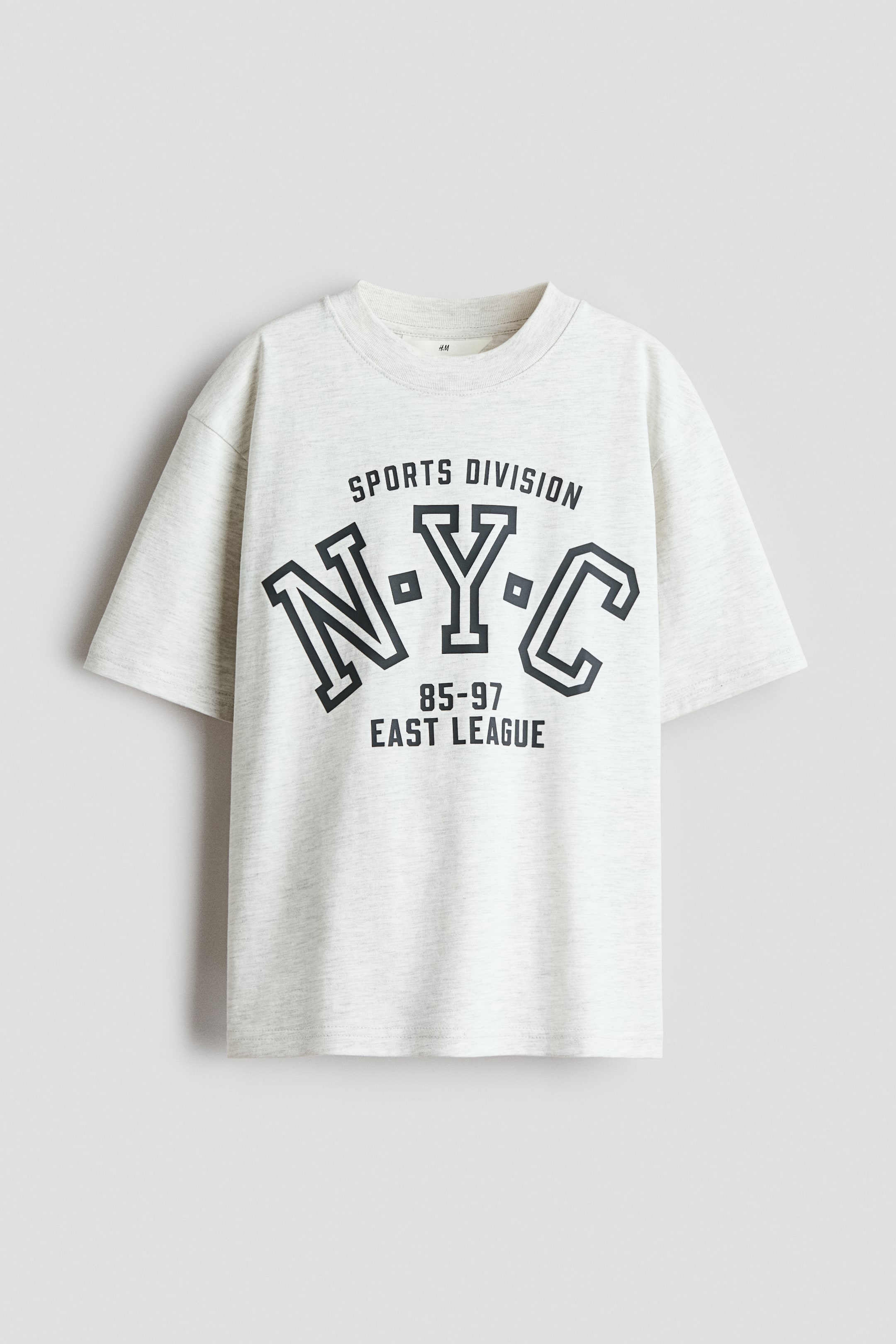 View larger image: A loose-fit t-shirt showcasing its front, crafted from light grey marl cotton jersey, features a ribbed trim around the neckline and dropped shoulders. A dark grey graphic print adorns the chest, displaying 'SPORTS DIVISION N-Y-C 85-97 EAST LEAGUE', with the letters 'N-Y-C' prominently larger and outlined.
