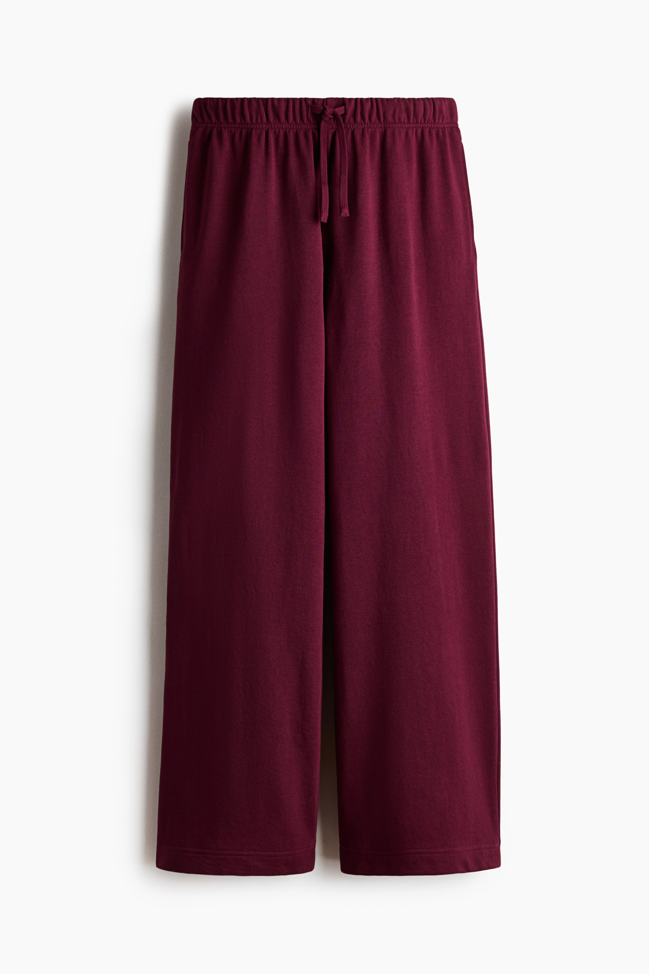 View larger image: Maroon joggers are shown from the front, featuring lightweight sweatshirt fabric, an elasticated drawstring waist, discreet side pockets, and straight legs.