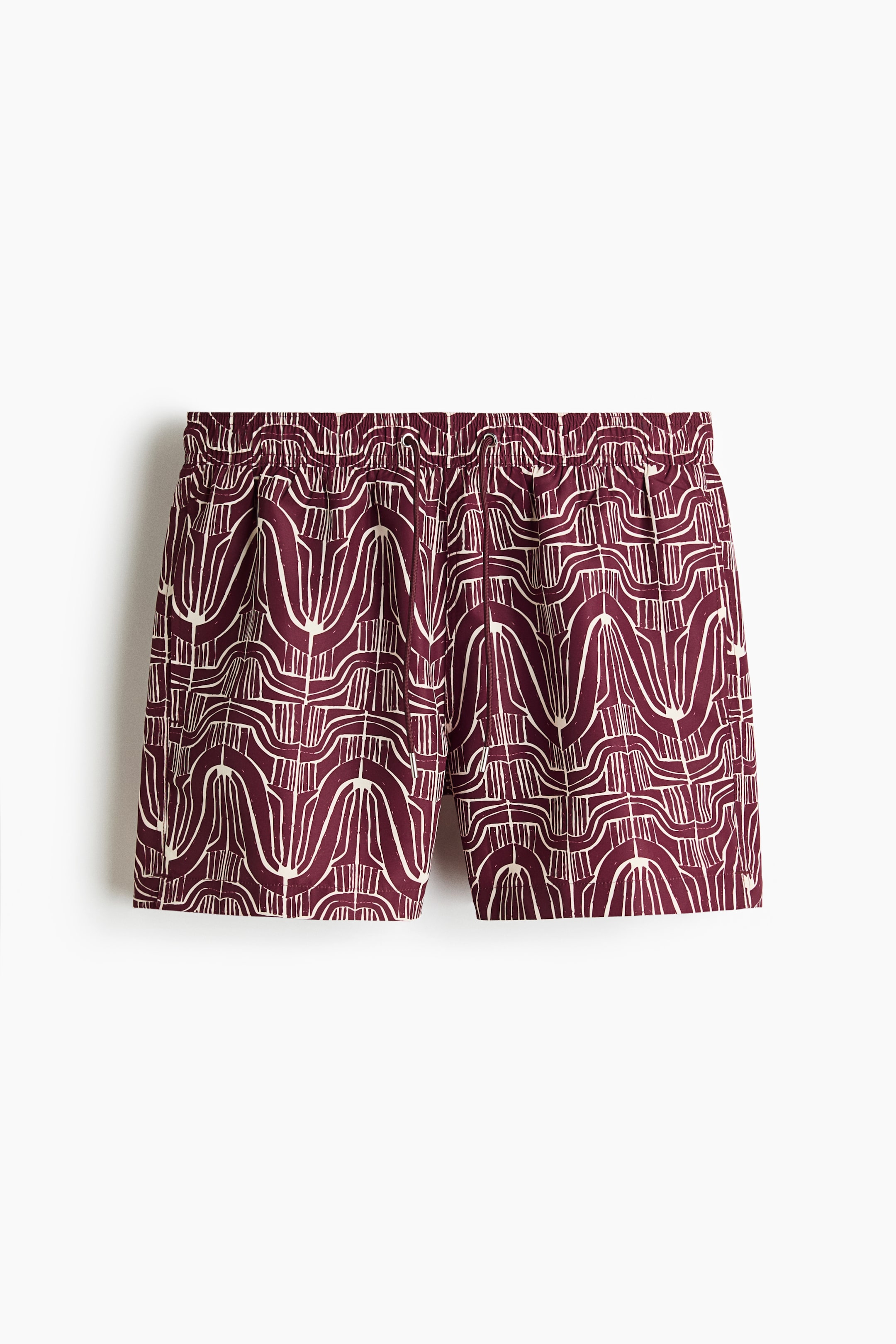 Agrandir l'image: Les shorts de bain sont présentés de face, mettant en valeur un tissu tissé bordeaux avec un motif abstrait de lignes courbes en blanc cassé. Ils sont conçus avec une taille élastiquée et froncée, affichant des œillets discrets pour cordon de serrage.