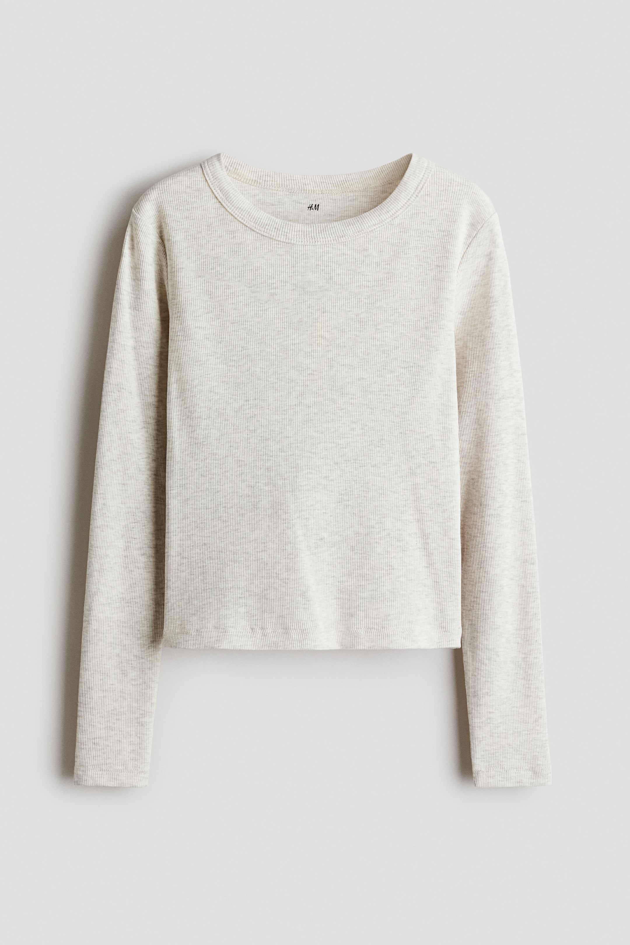Se større billede: En frontvendt, lys meleret beige langærmet top har en markant ribstrikket tekstur og er udstyret med rund hals, lange ærmer og en lige, cropped kant.