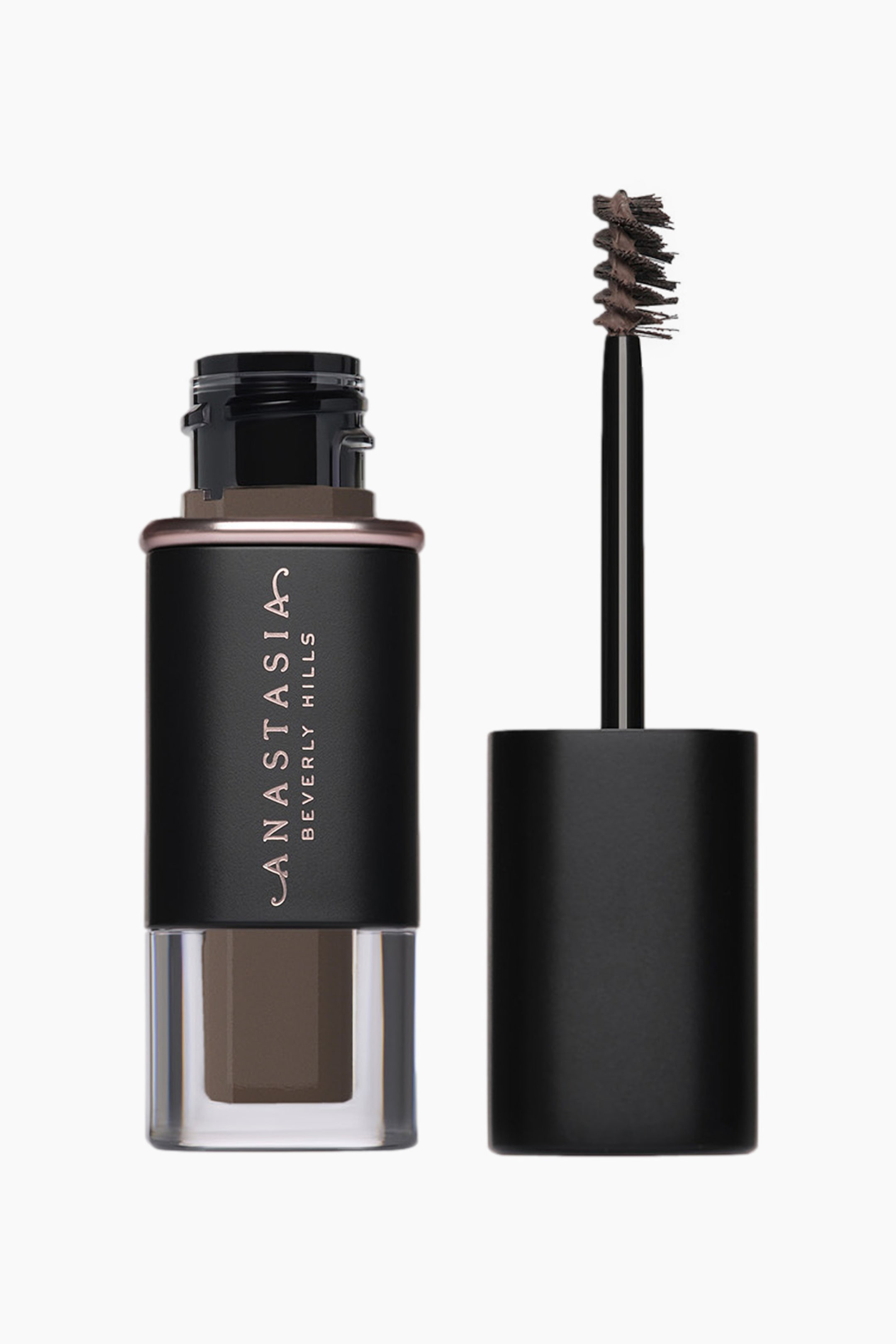 Se større billede: En bryngelbeholder står oprejst, med en mat sort krop med 'Anastasia Beverly Hills' branding i rosaguld, en gennemsigtig bund der viser den mørkebrune gel, og et rosaguldbånd omkring halsen. Ved siden af står applikatorstaven også oprejst, med en mørkebrun, tilspidset spooliebørste, der er dækket med produkt og strækker sig fra en separat mat sort hætte.