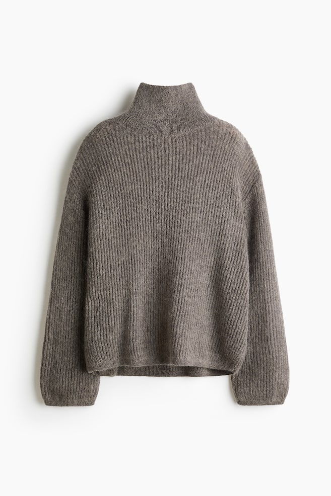 Un jersey oversize de punto canalé con mezcla de mohair y textura marrón se muestra de frente, con cuello alto vuelto, hombros caÃdos y mangas largas y anchas. El jersey presenta una silueta relajada con bordes estrechos de canalé fino en los puños y el bajo. - 1