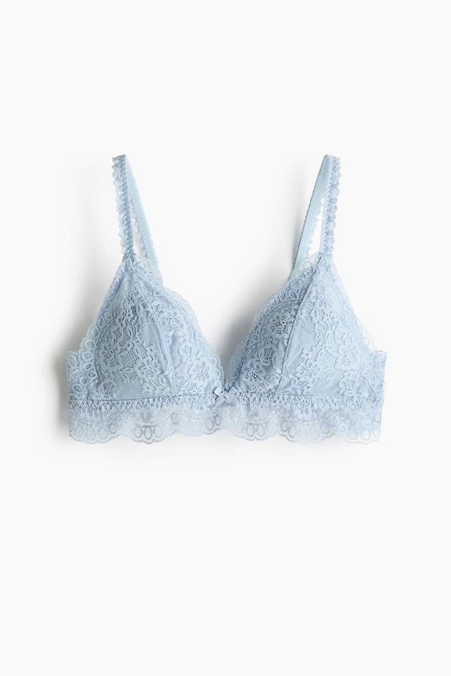 A light blue lace bra is facing front, featuring delicate floral patterns throughout its non-wired, triangle-shaped cups. It showcases adjustable lace shoulder straps, a small bow at the centre gore, and a scalloped lace trim along the bottom band. - 1