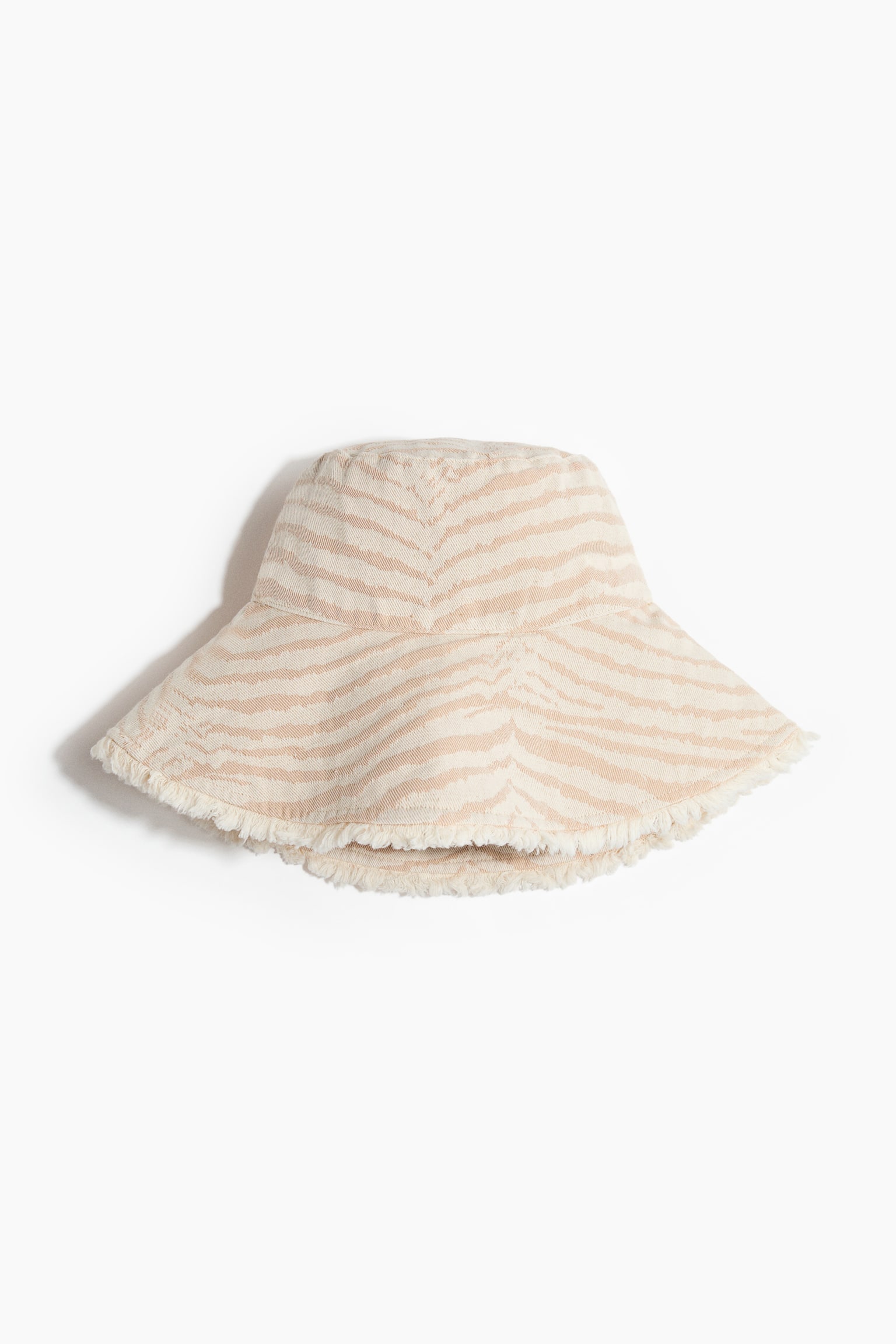 A bucket hat featuring a beige and off-white zebra print in a robust weave, with a wide, sloping brim and a frayed edge. - 1