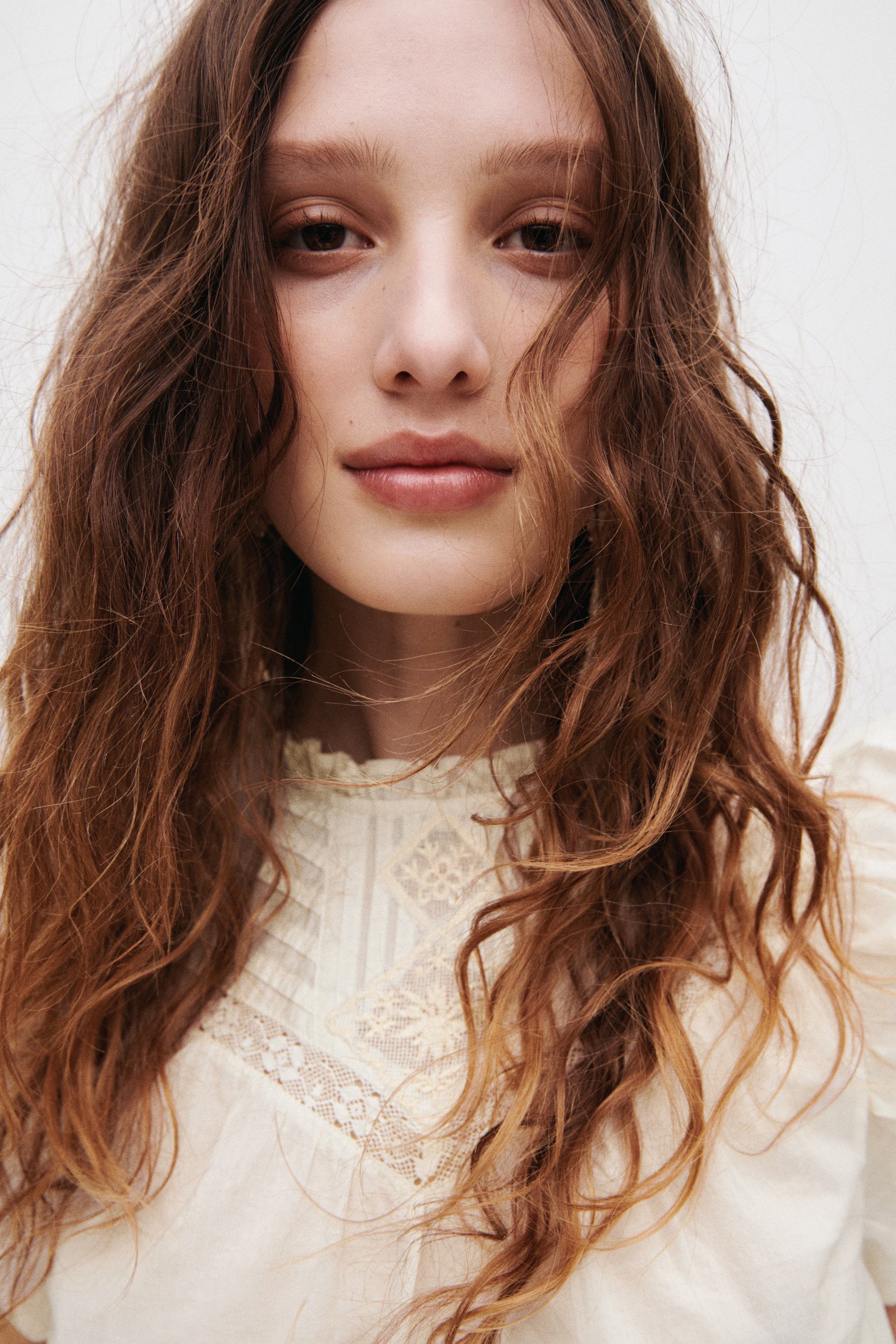 Voir une image plus grande: Un haut en tissage de coton léger est porté par le mannequin, avec un col orné de volants et un empiècement en forme de V avec des plis nervurés et des détails brodés à l'avant.