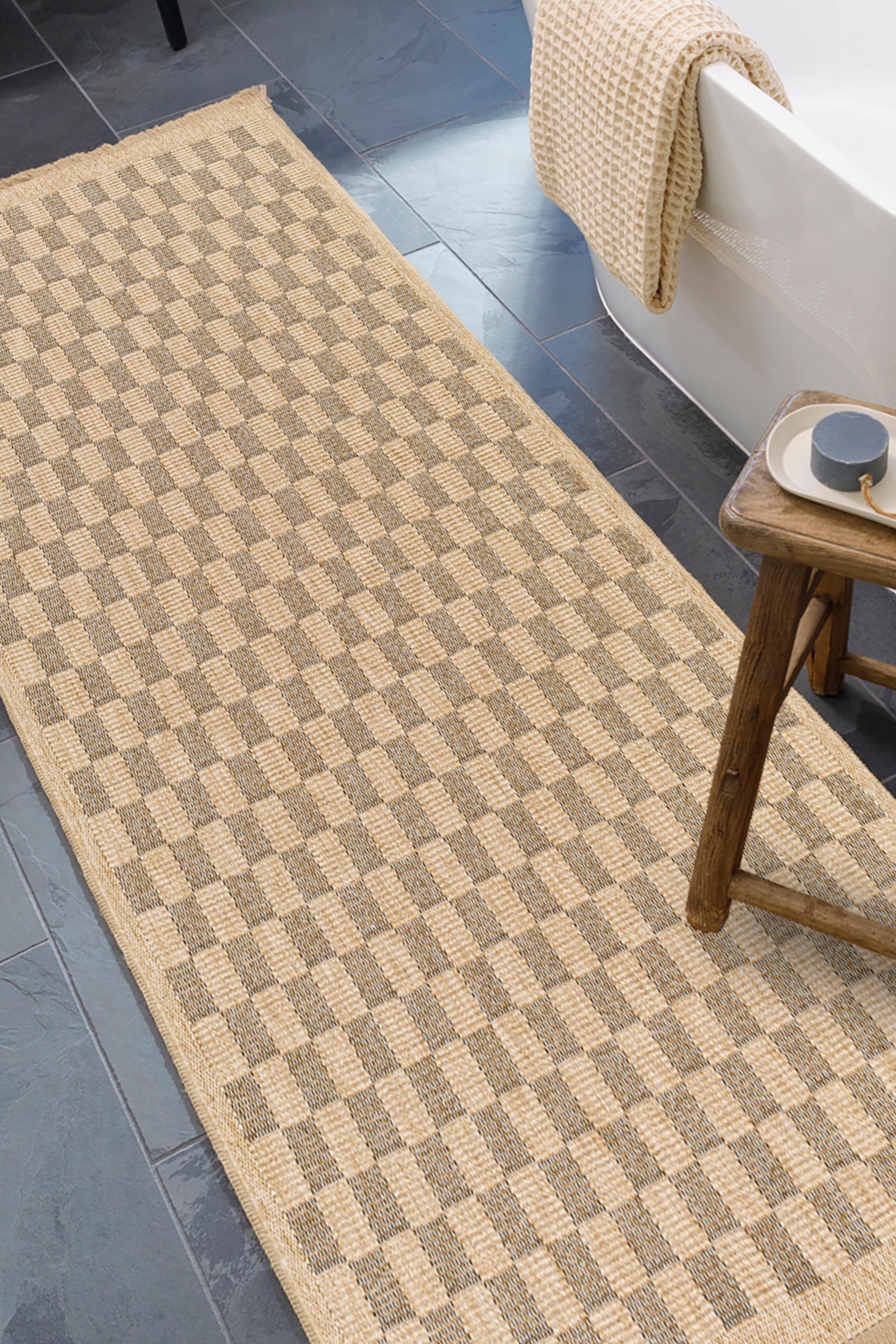 View larger image: A rectangular runner rug featuring a chequered pattern composed of alternating light beige and darker beige squares. It is woven with a visible texture and lies flat, extending diagonally from the lower left to the upper right.