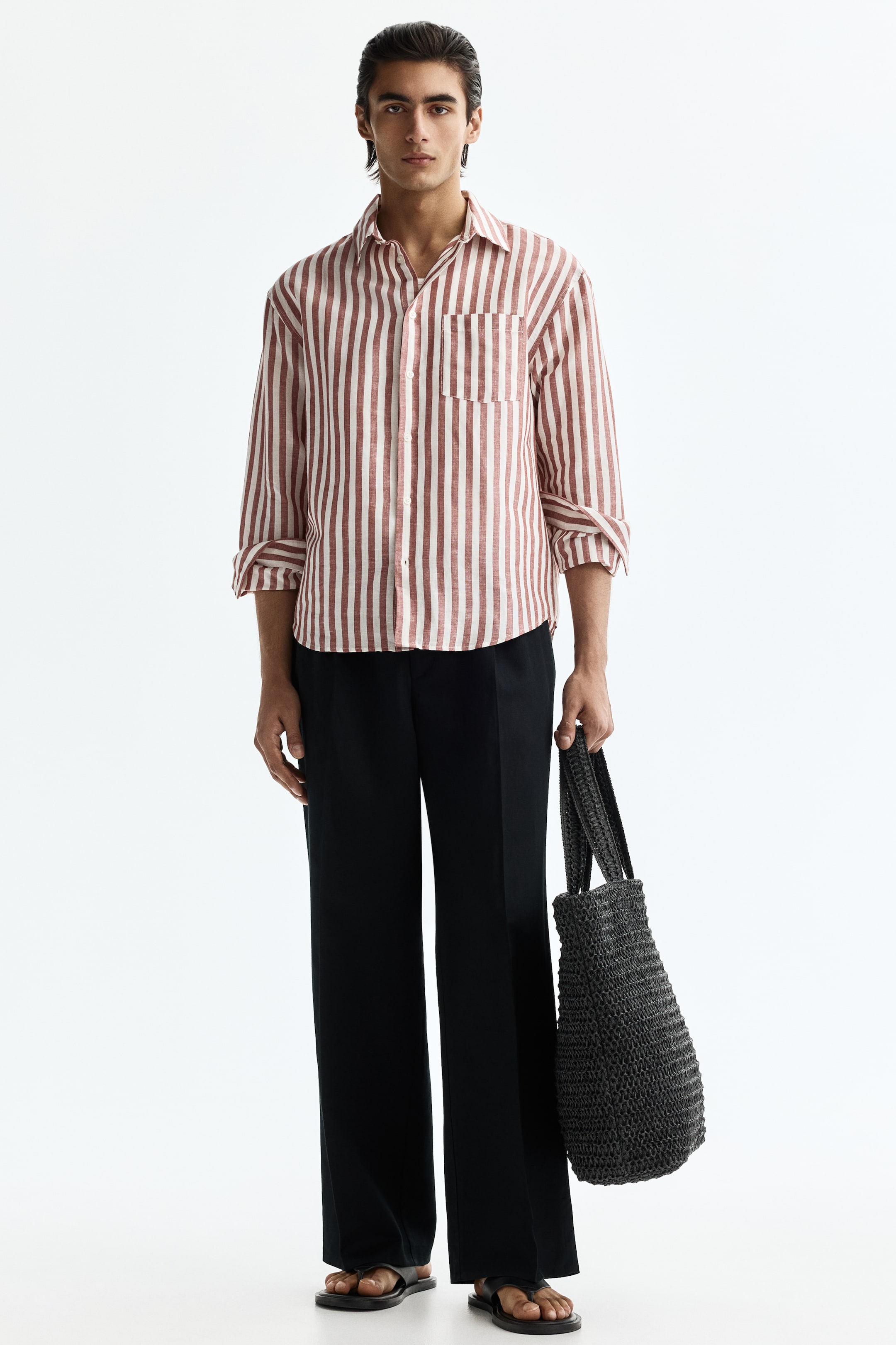 View larger image: A men's button-up shirt features vertical reddish-brown and white stripes on the front. It's crafted with a classic point collar and includes a single patch pocket on the left chest. The long sleeves are rolled up to the elbows.