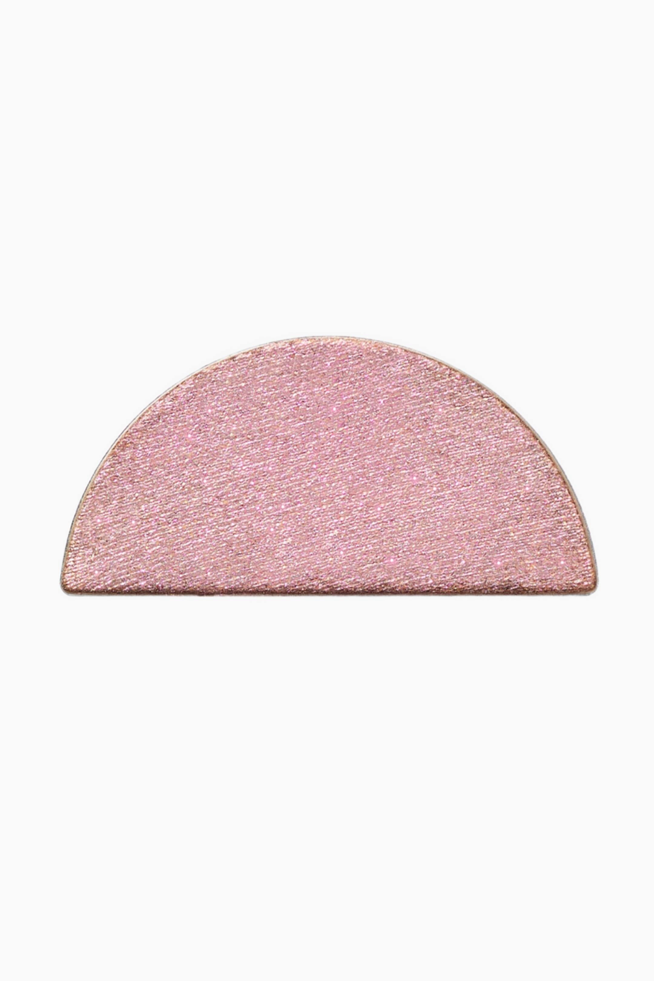 Visa större bild: Ett rosa halvcirkelformat kosmetikapann ligger plant och visar upp en skimrande, fint texturerad yta.