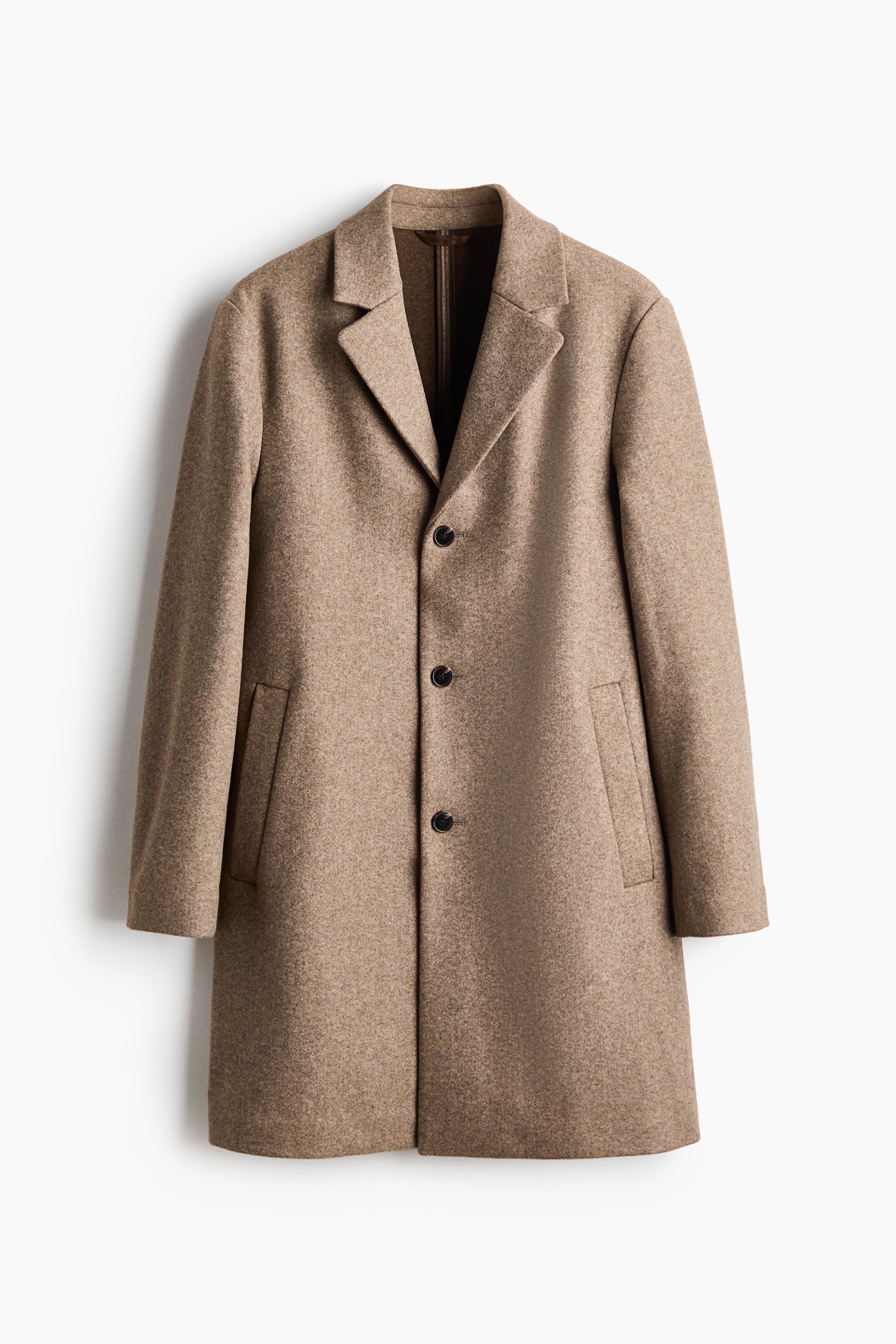 Se større billede: En beige uldfrakke med enkeltknaplukning vises forfra med revers med hak og tre mørke knapper. To skrå paspolerede lommer er synlige på frakkens front, og stoffet har en let tekstureret overflade.