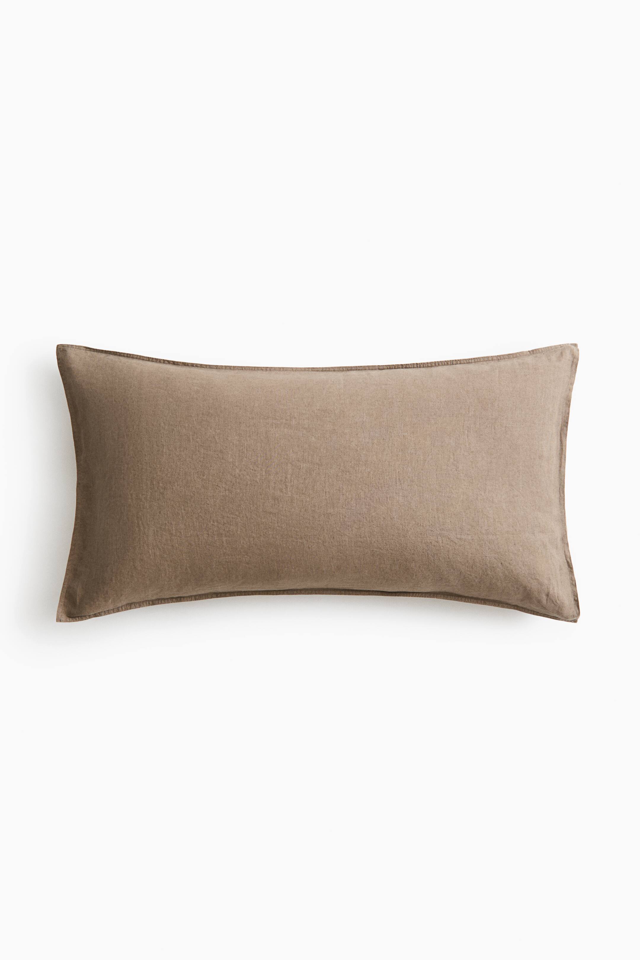 View larger image: A rectangular pillowcase in muted taupe-brown washed linen lies flat and facing forward. The pillowcase features a slightly textured surface and double-stitched edges along the outer border.
