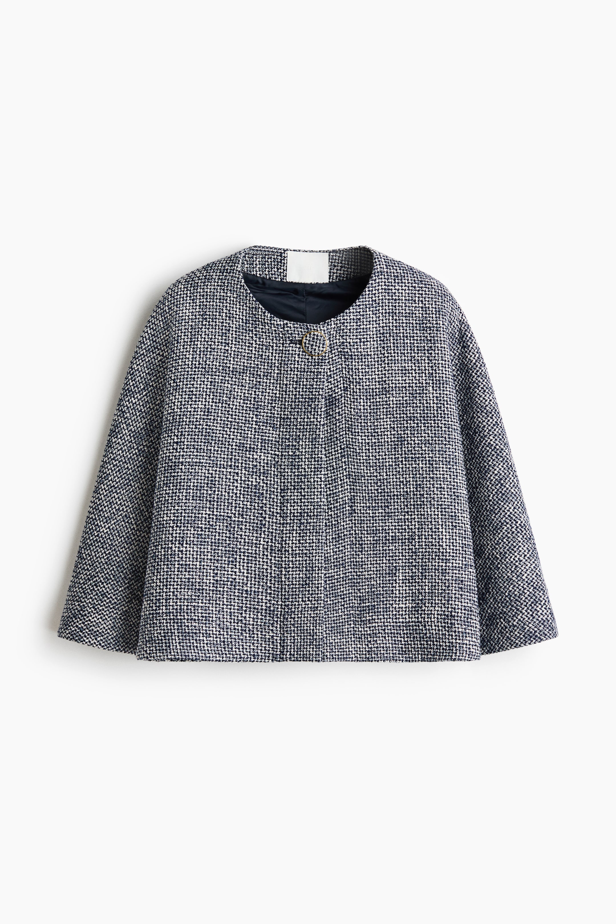 Agrandir l'image: Une veste cape courte et ample présente sa vue de face, mettant en valeur un tissage robuste et texturé dans un motif moucheté sombre et clair. Elle est conçue avec un col rond, un bouton recouvert en haut, des boutons-pression dissimulés sur le devant et est doublée.