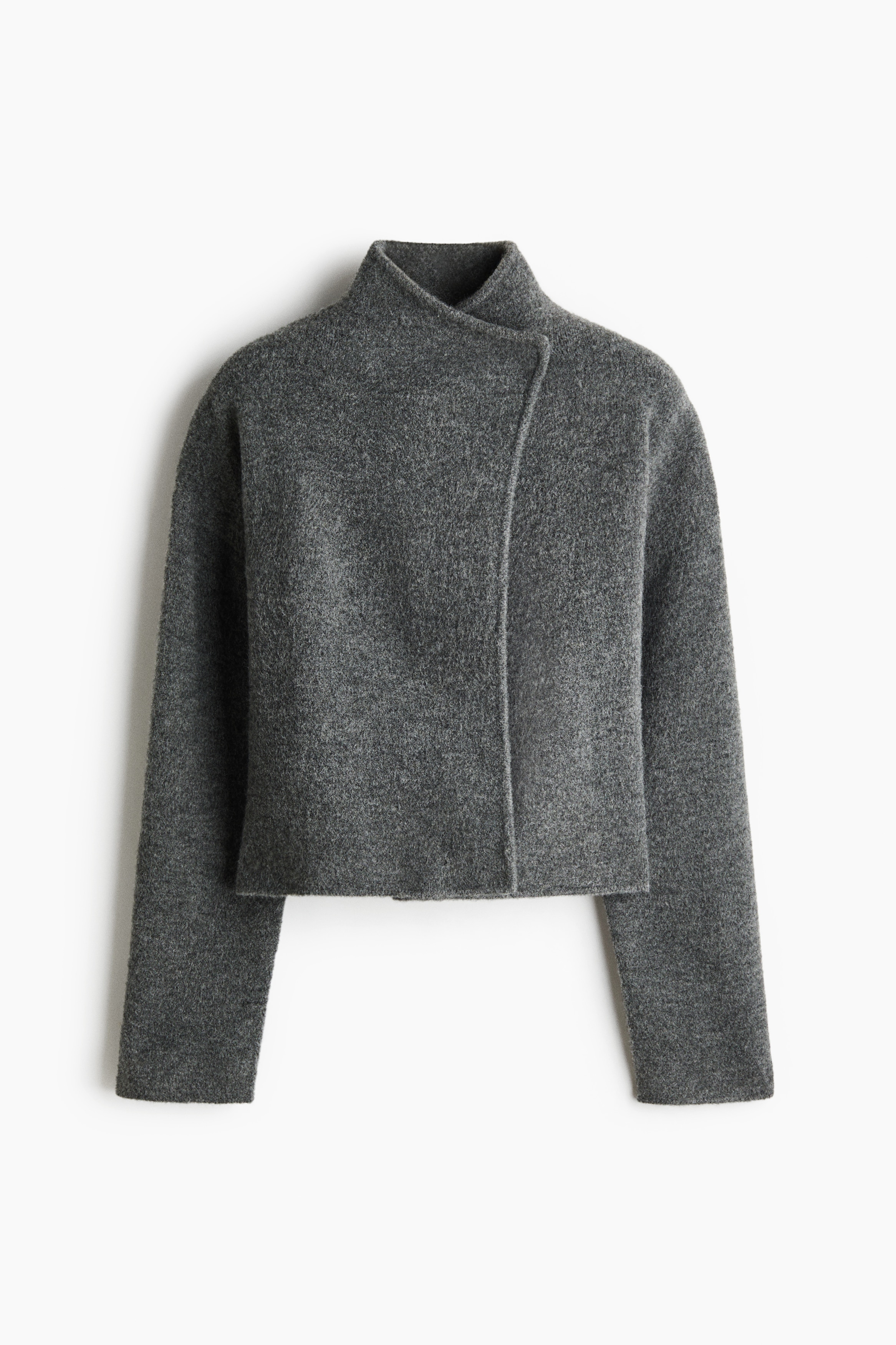 A short, dark grey cardigan in a soft, brushed knit is being worn by the model, featuring a stand collar, a wrap front, and dropped shoulders. The cardigan is styled with a black mini skirt.